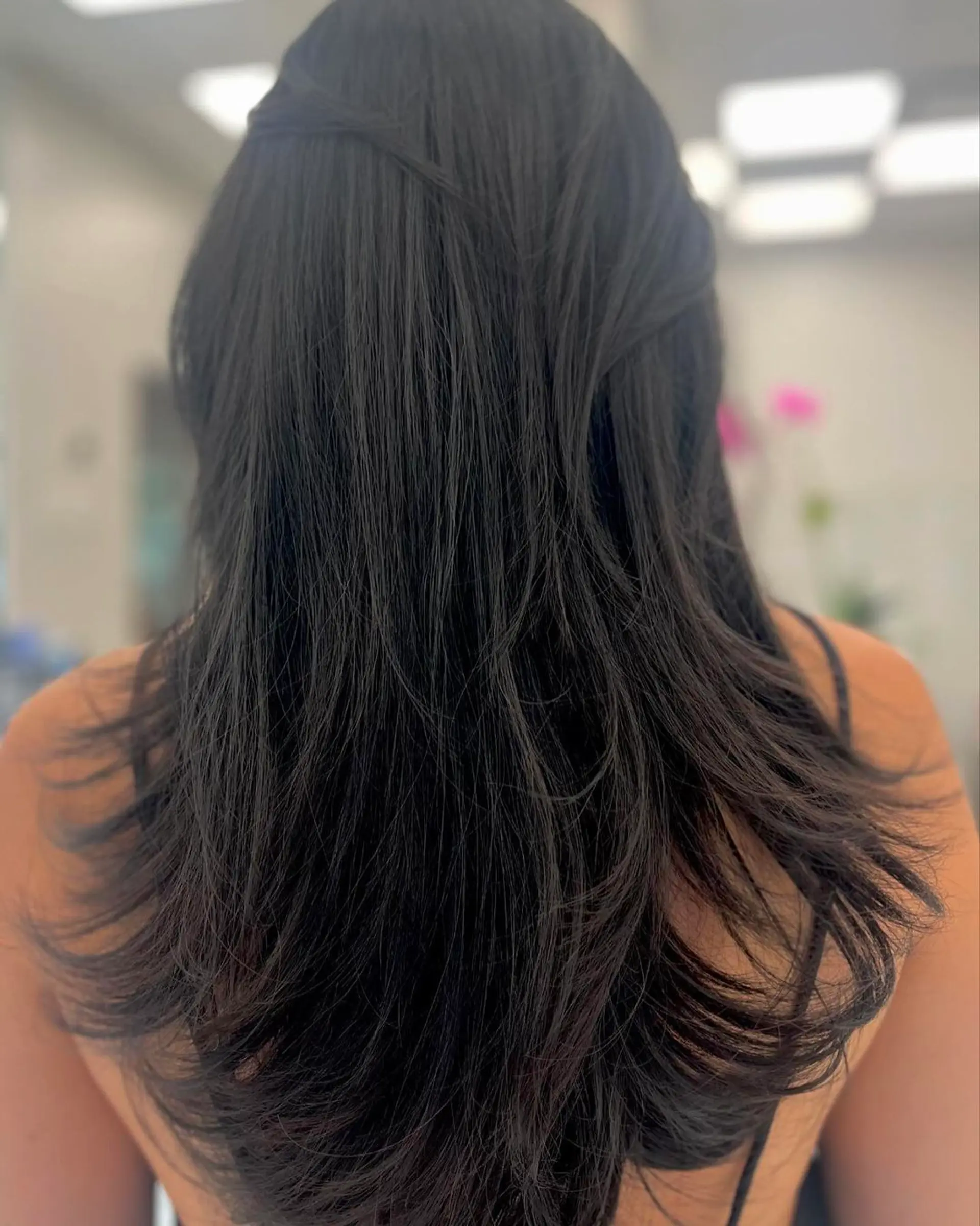 Long, straight, layered dark brown hair with a smooth and lustrous finish. 1