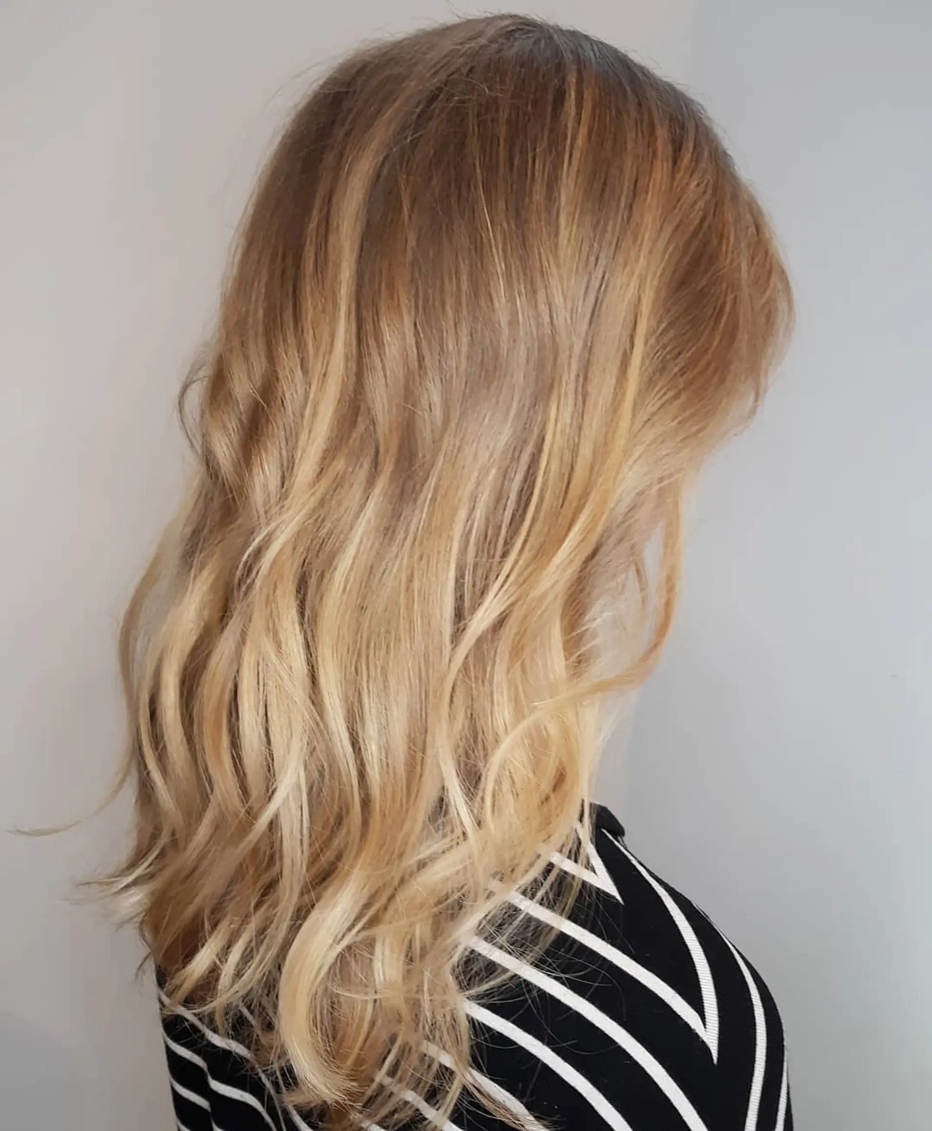 Long, wavy hair with golden blonde balayage and loose beach waves. 1