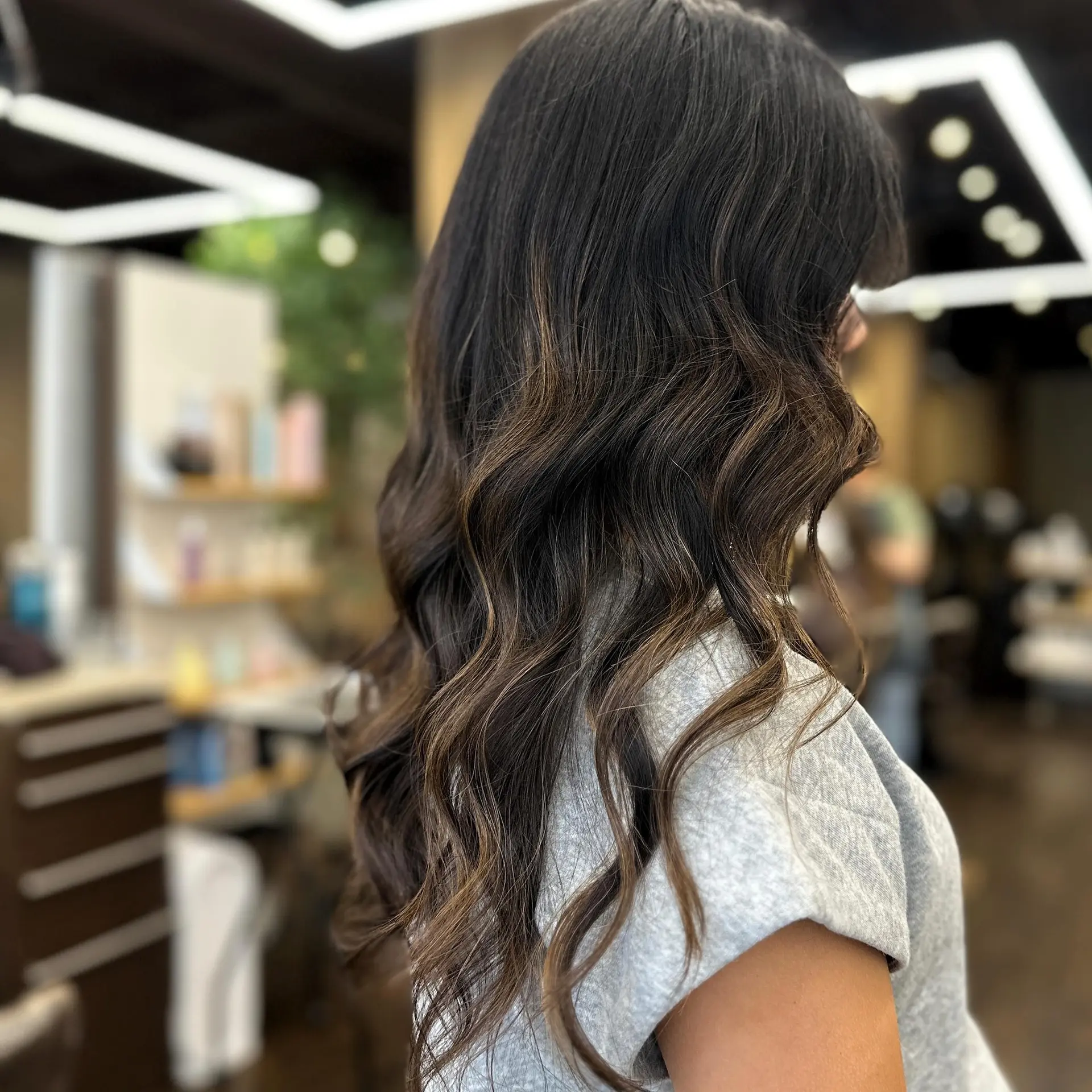 Long wavy hair with bronzed balayage highlights and face-framing layers. 1