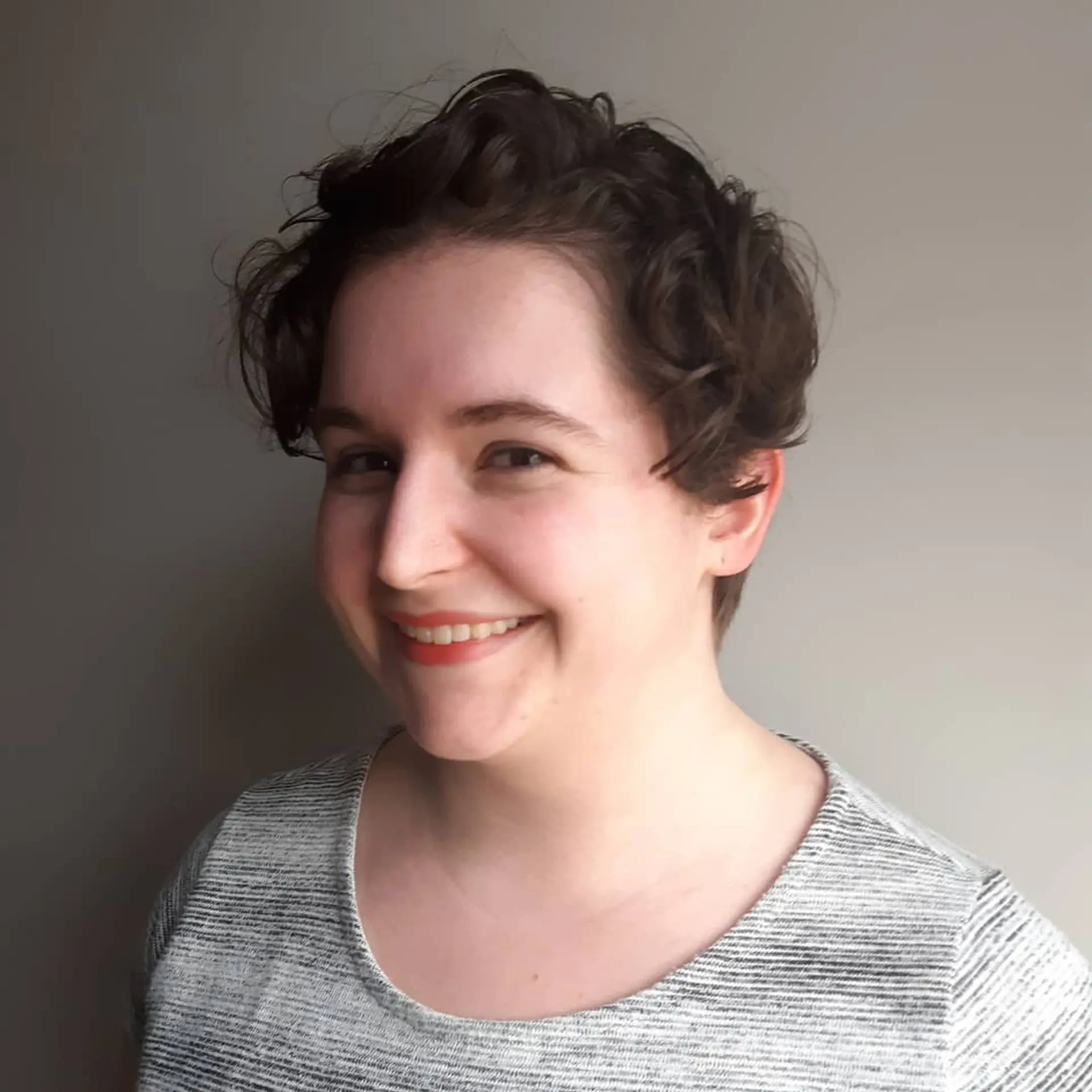 A short, textured pixie cut that enhances natural curls and provides an effortless, stylish look. 2