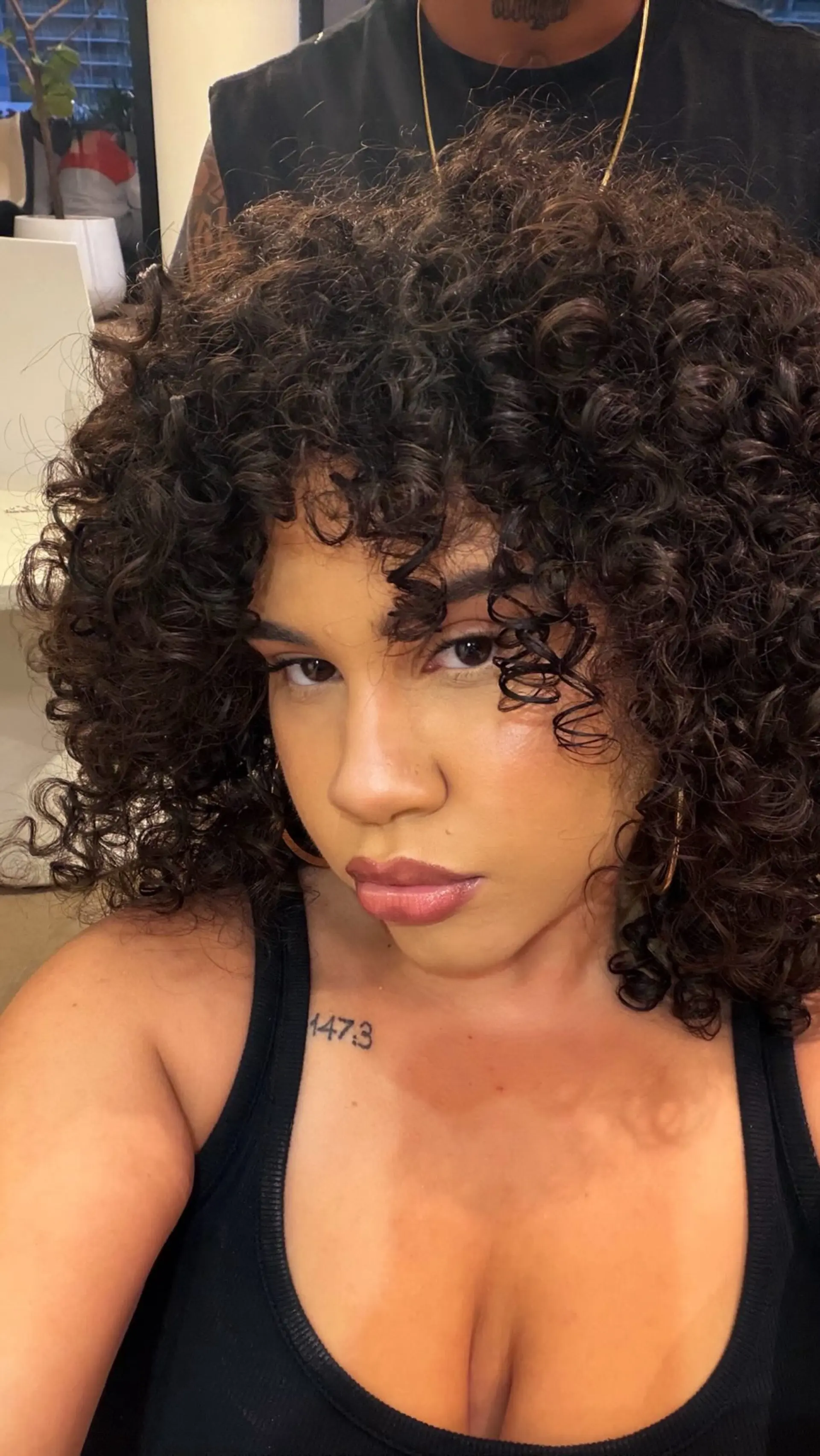 Shoulder-length voluminous curly haircut with defined ringlets and curly fringe framing the face. 1