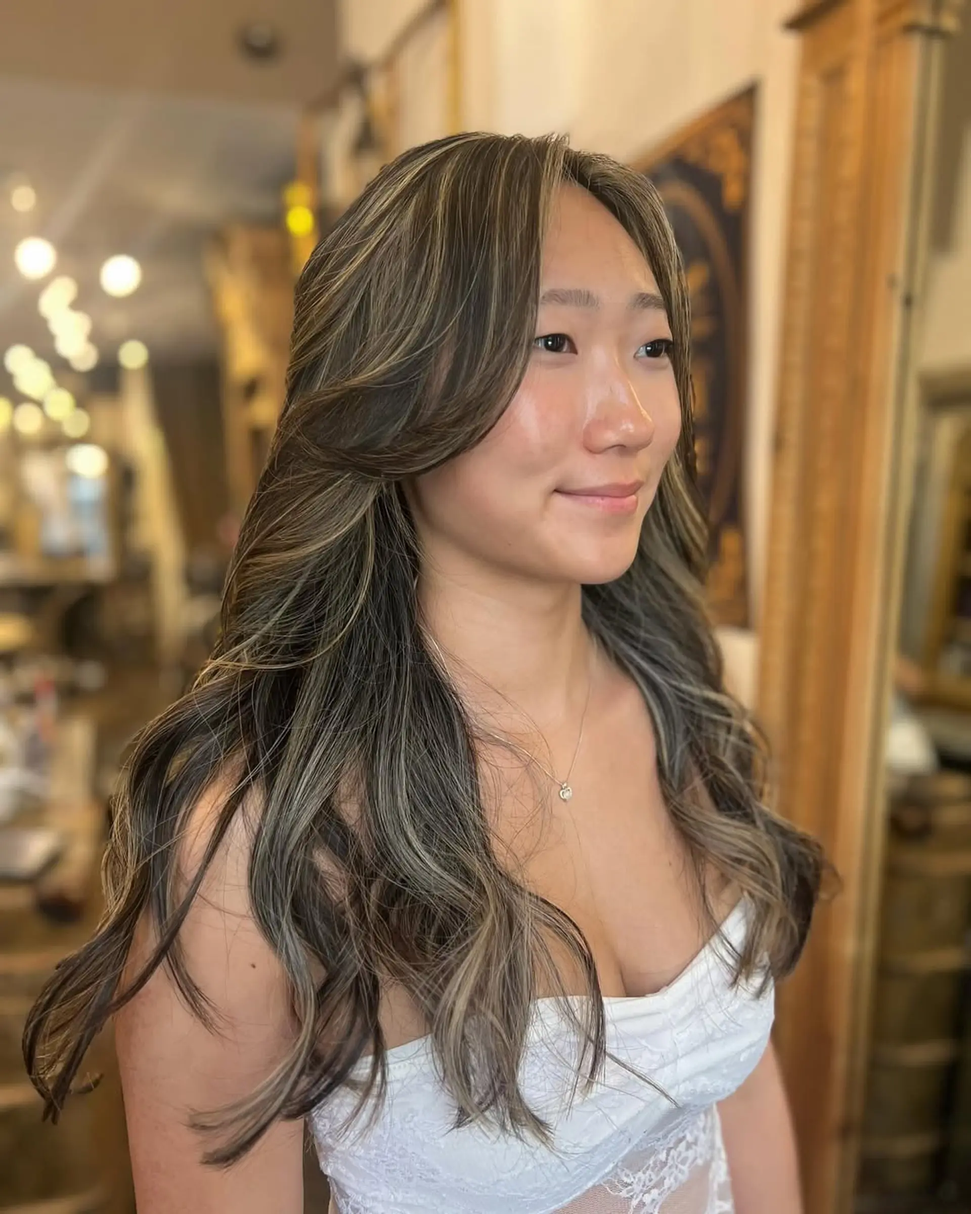 Long, wavy hair with ash blonde highlights on dark brown base, layered for volume with face-framing waves. 1