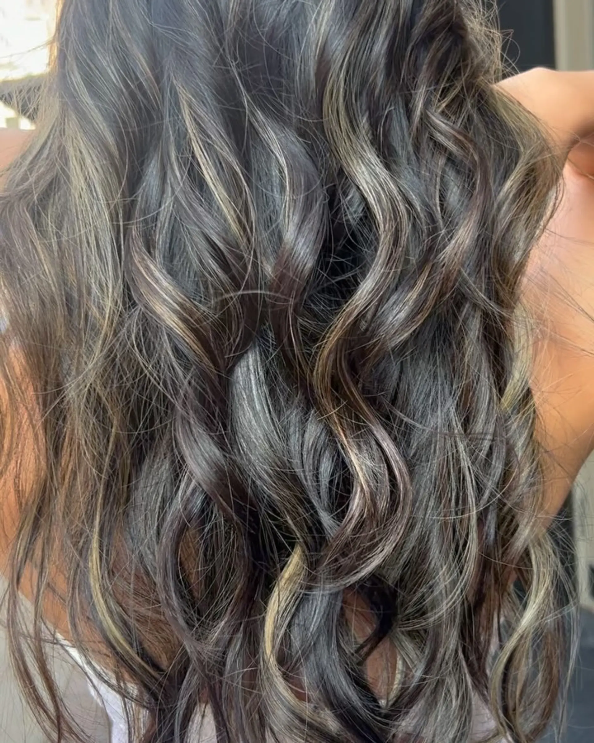 Long, wavy hair with ash blonde highlights on dark brown base, layered for volume with face-framing waves. 4