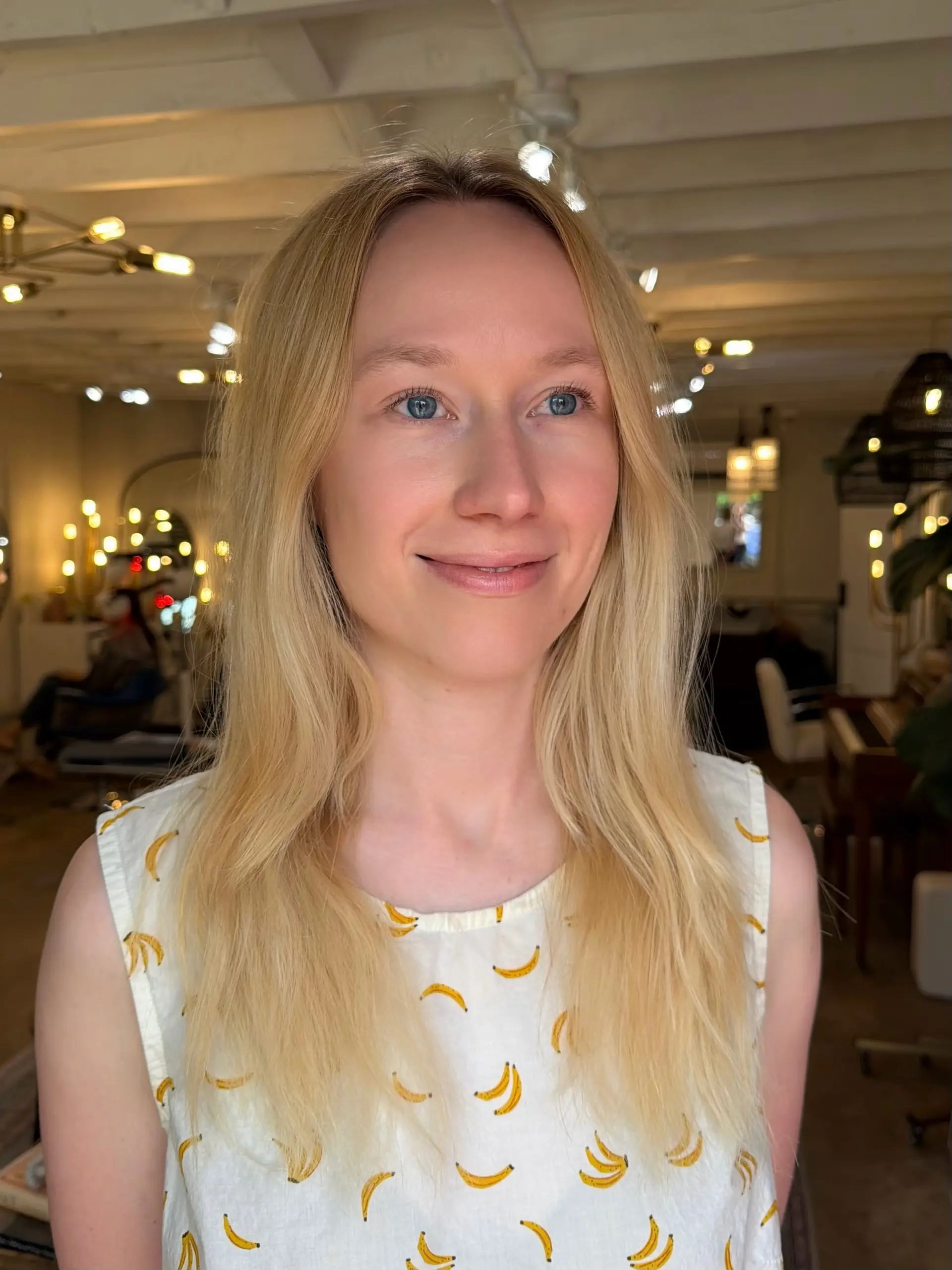 Long, fine light blonde hair styled straight with a center part and textured ends. 1