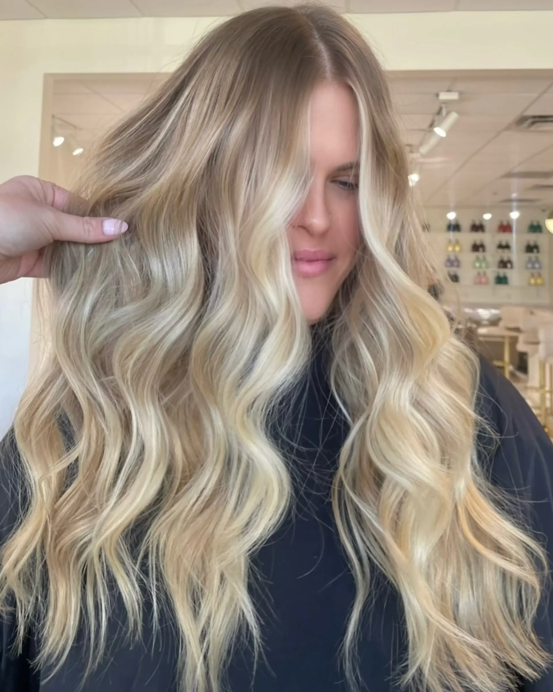 Dimensional sunkissed blonde balayage styled with flowing, voluminous loose waves. 1