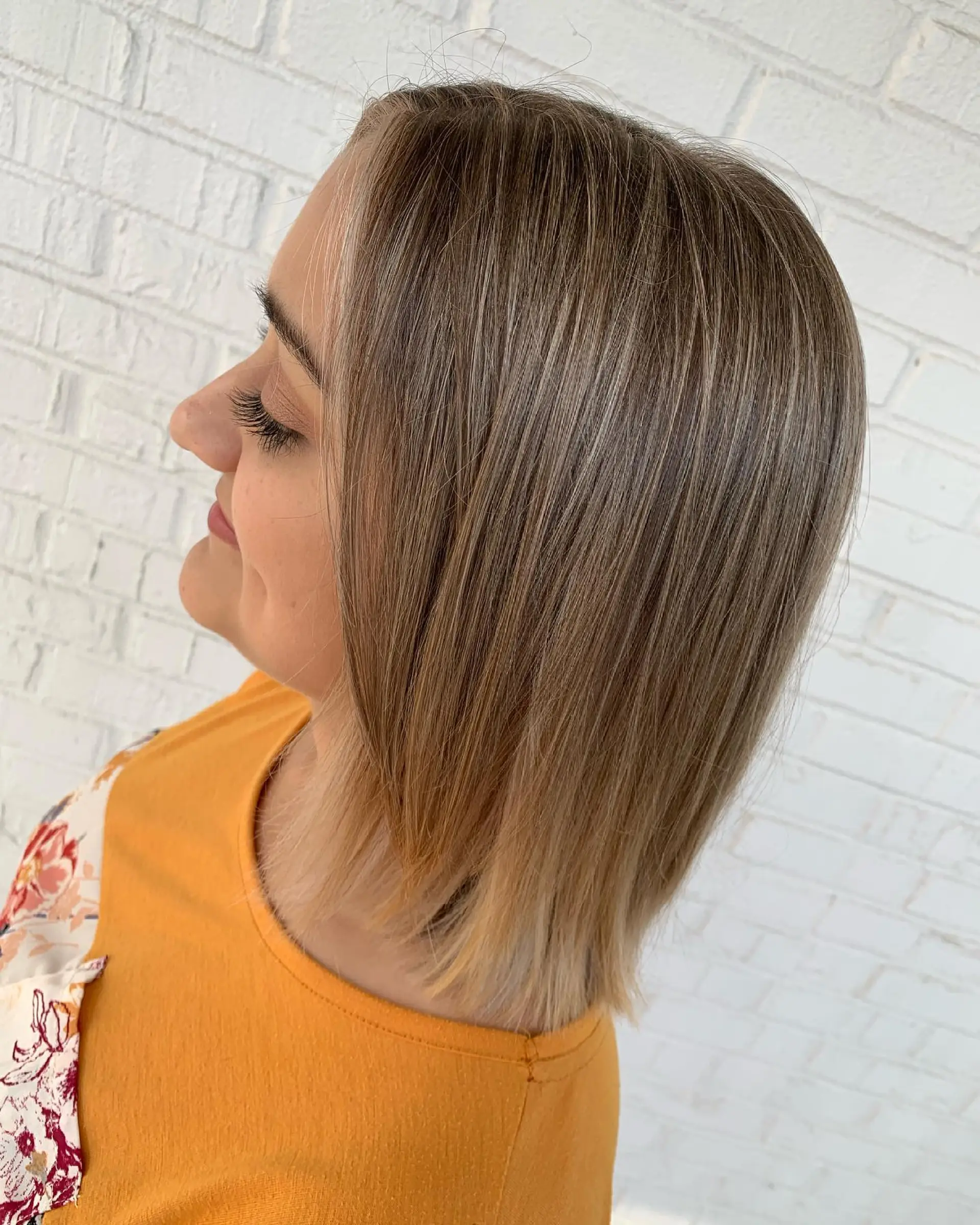 A sleek, shoulder-length blunt cut styled straight with seamlessly blended blonde balayage highlights over a natural light brown base. 1