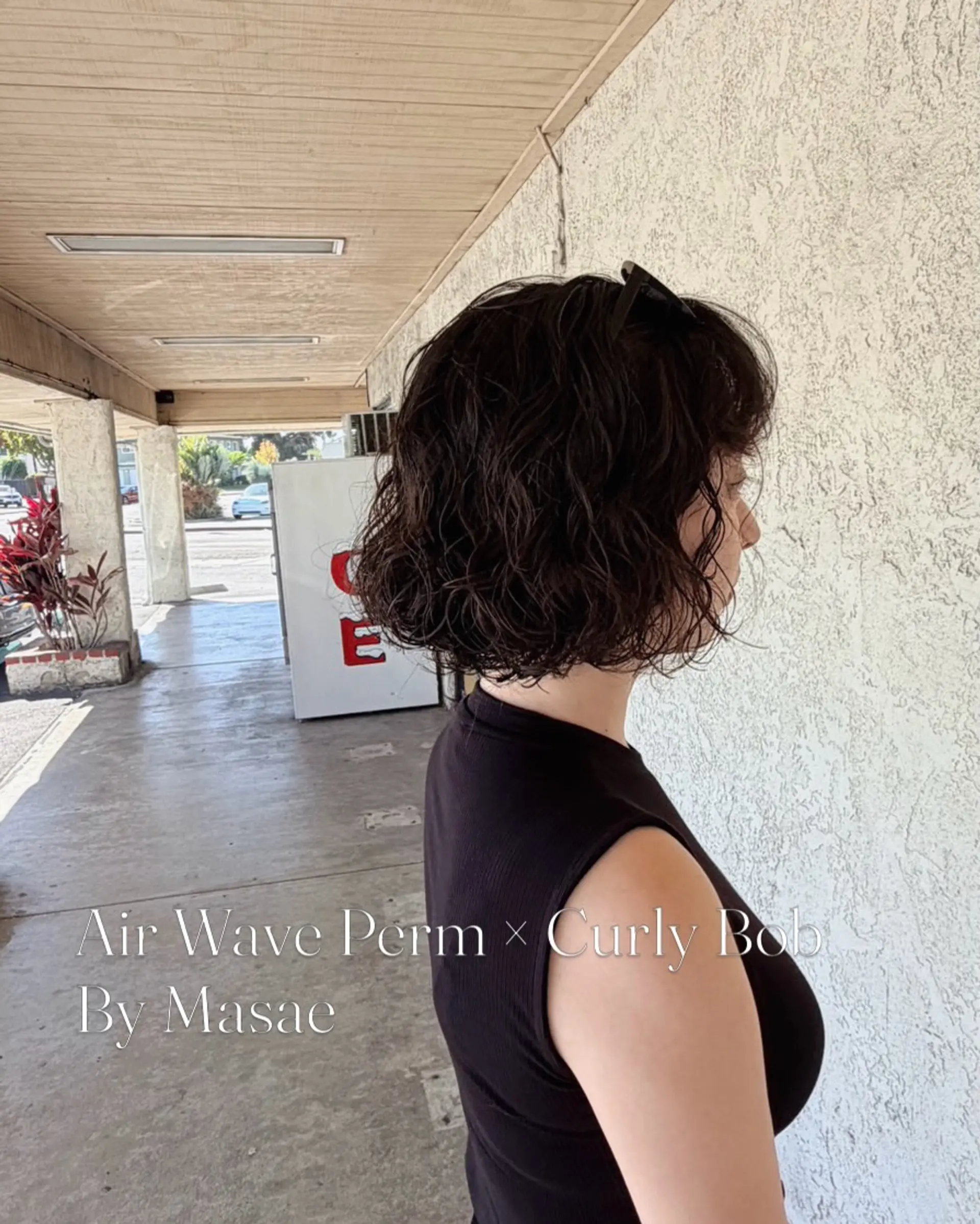A chin-length textured bob styled with airy, soft perm curls that provide natural bounce and movement. 1