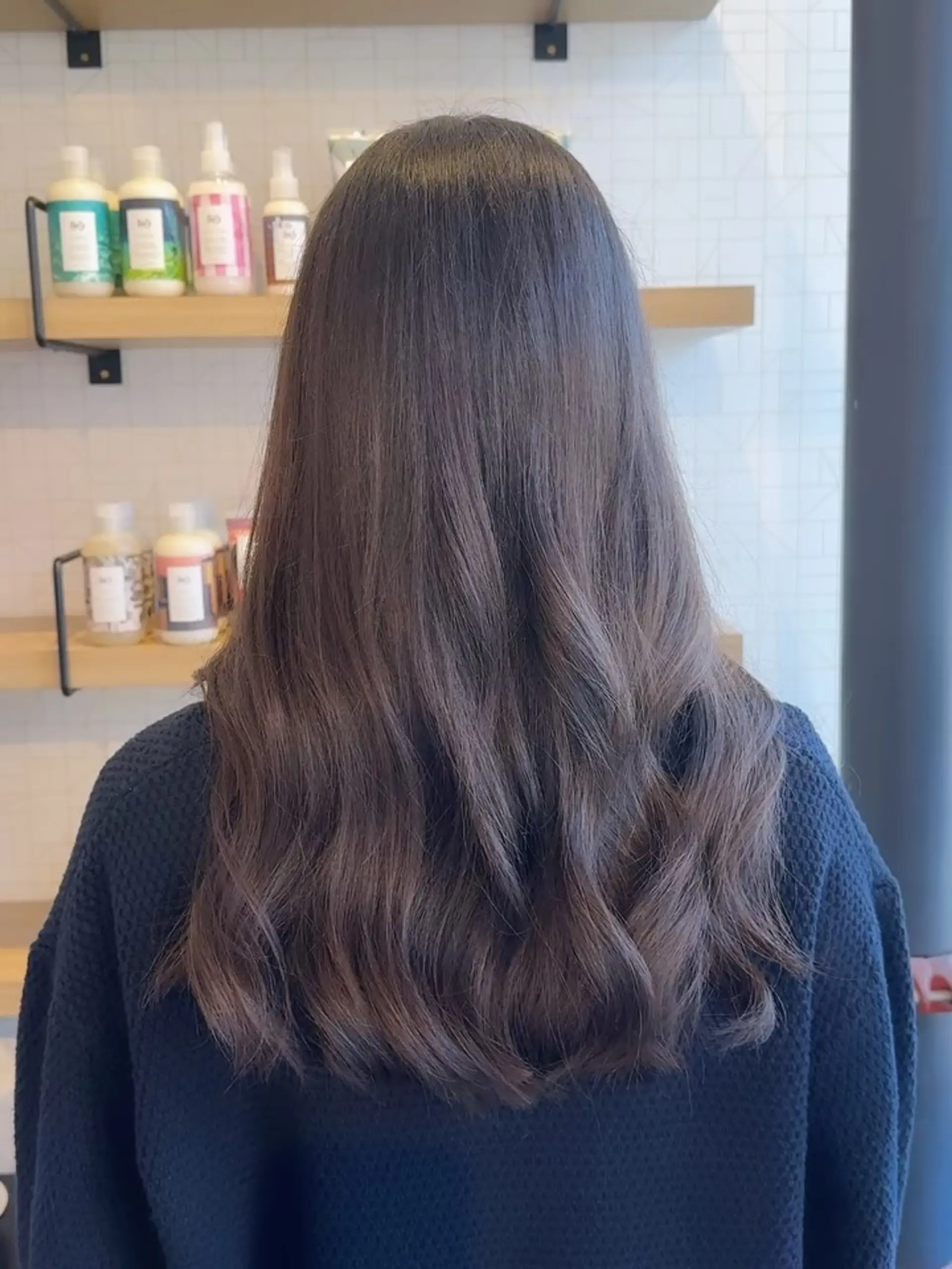 Long dark ash brown hair cut with gentle layers and styled in soft loose waves. 1