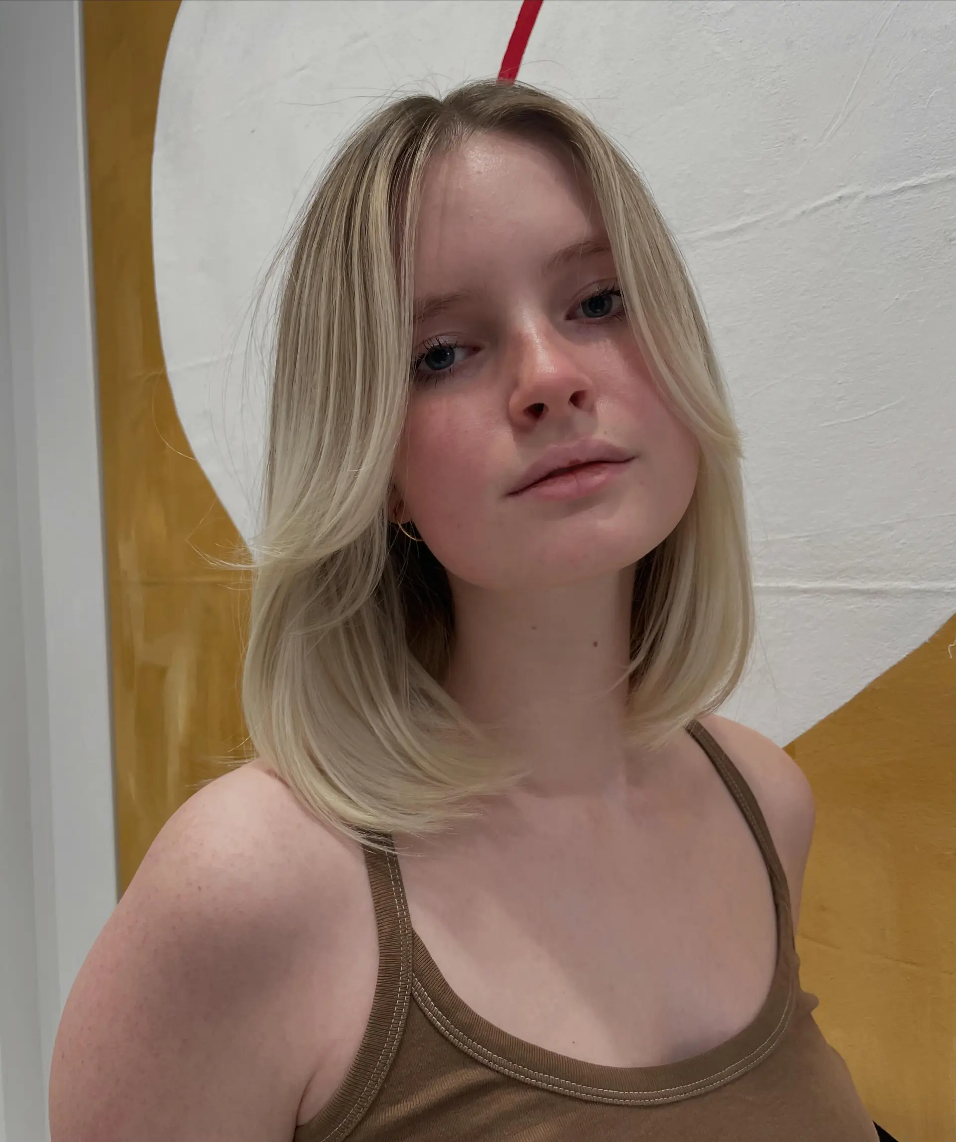 A smooth shoulder-length blonde lob featuring gentle face-framing layers and softly curved ends. 1