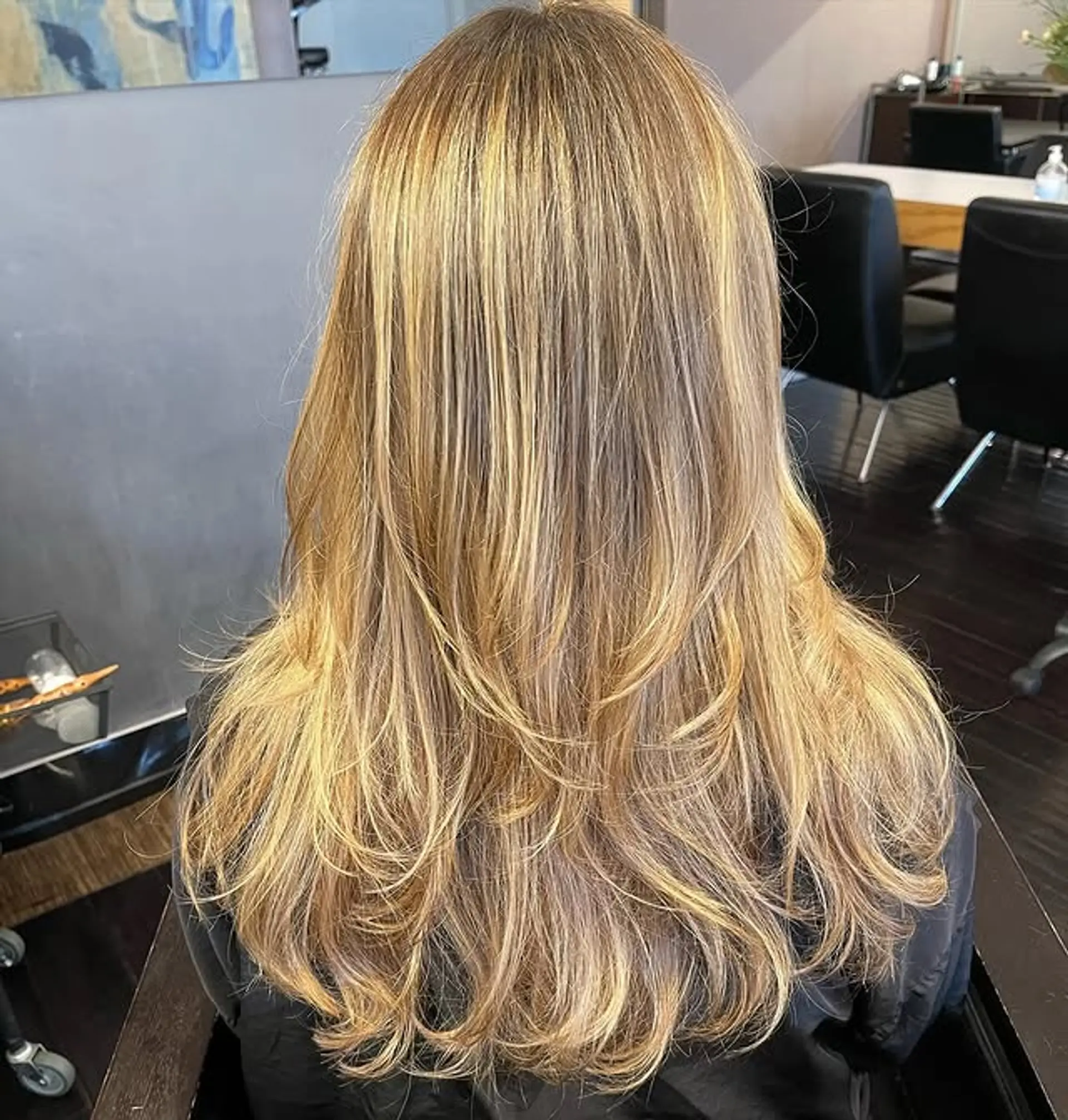 A long layered haircut with blended blonde tones. 1