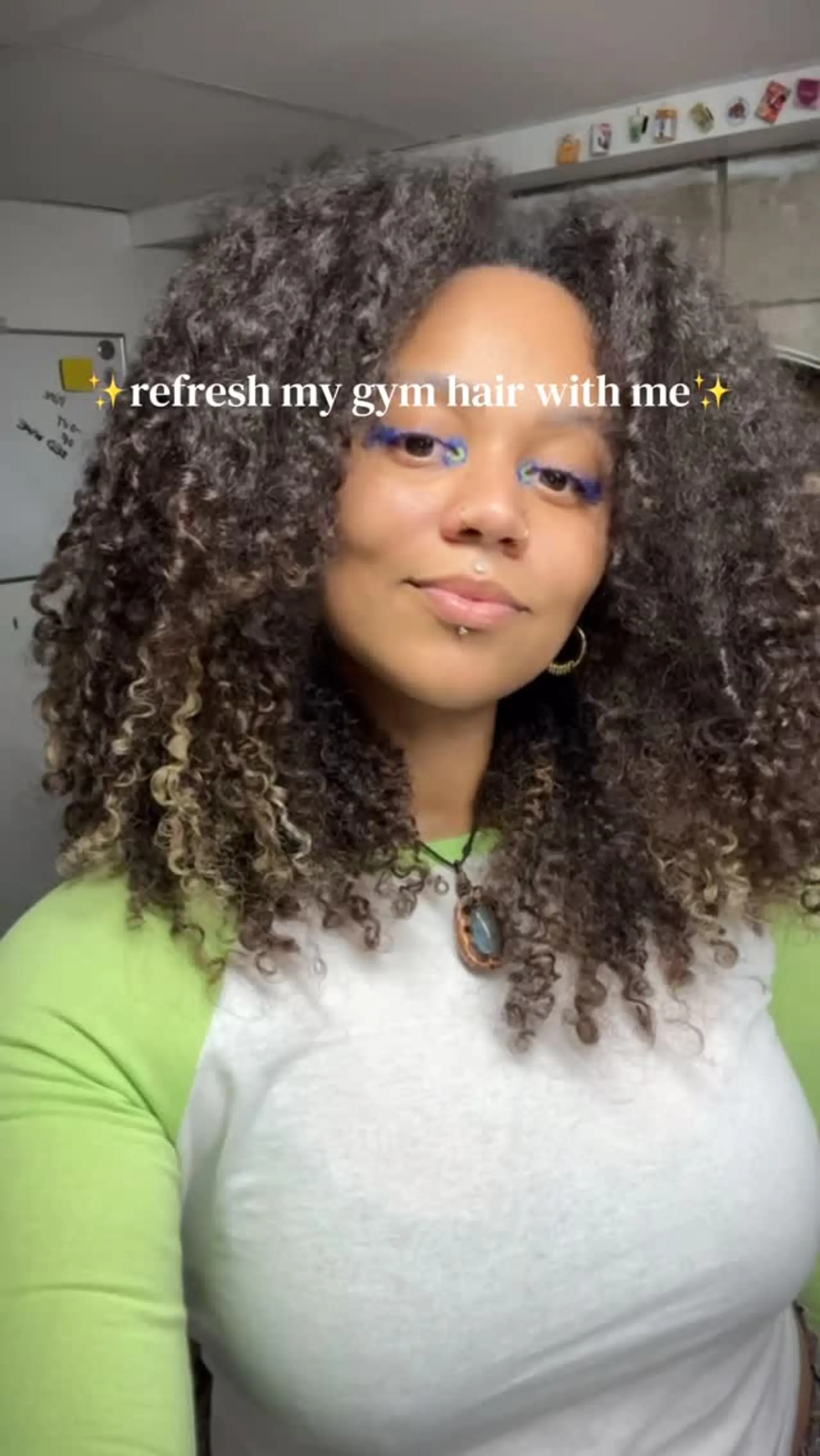 Voluminous, shoulder-length natural tight curls with lighter face-framing tips. 1