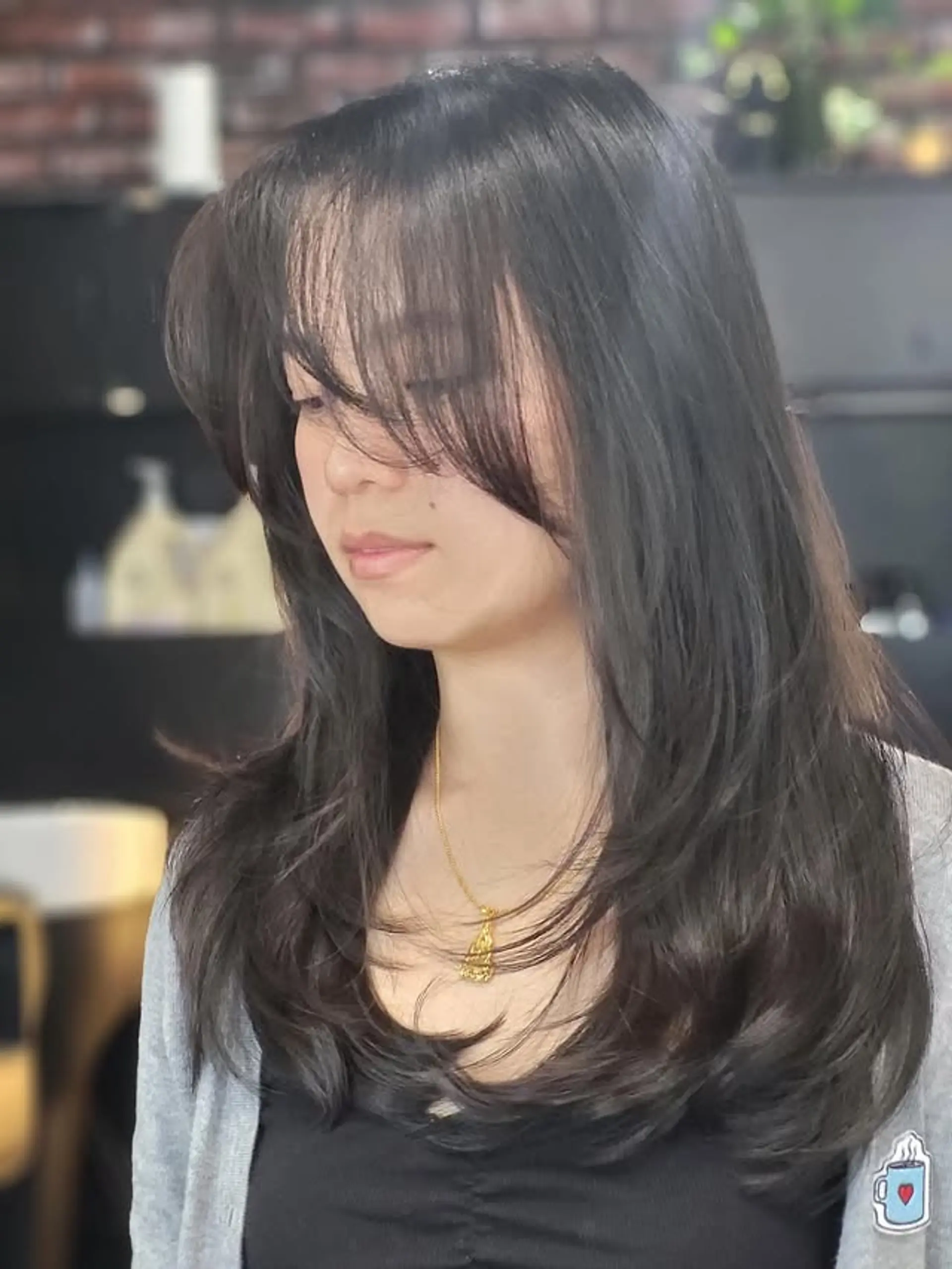 This modern layered haircut creates beautiful movement and volume, characterized by strategic face-framing layers and soft, swept-aside curtain bangs that elegantly frame the face. The ends are softly flipped or waved for a bouncy finish. 1