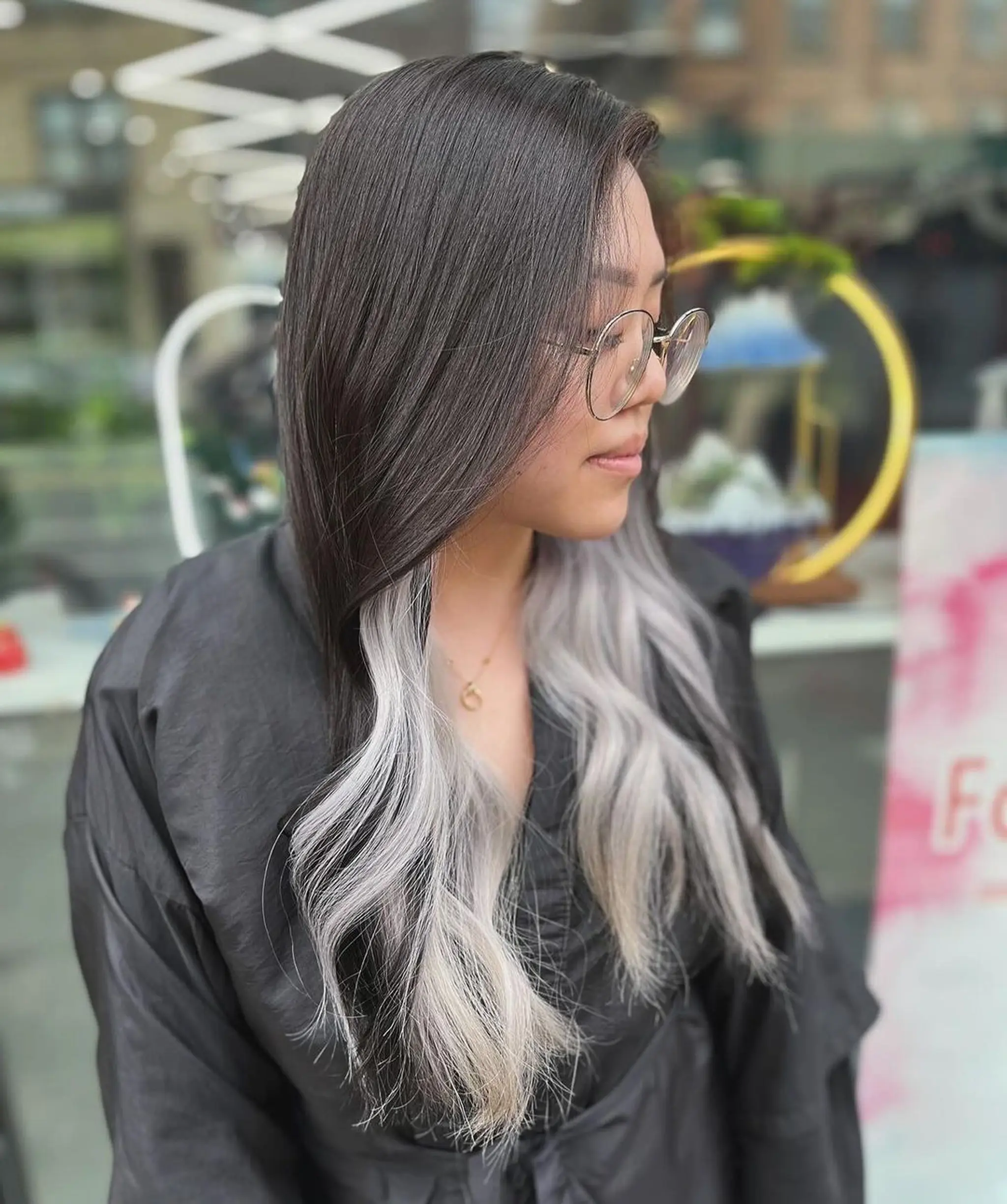 A sophisticated and stylish ombre hairstyle with long, straight hair transitioning smoothly from black at the roots to silver at the tips, featuring face-framing layers for added depth and dimension.
Stylist - @xcellent_jason