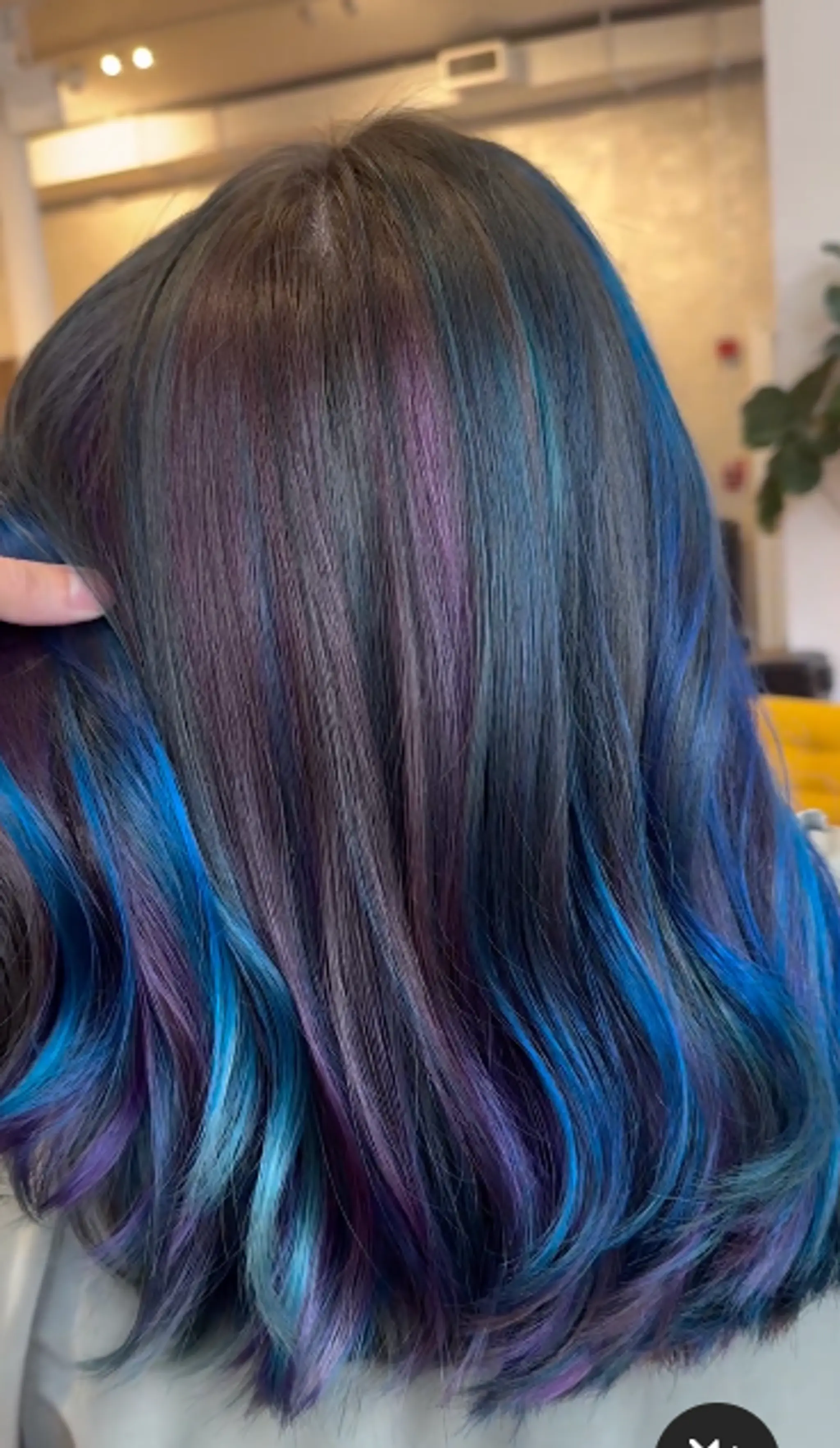 Stunning medium-length, straight hairstyle with black hair enhanced by vibrant streaks of blue and purple.

Stylist: @danieldoeshair
