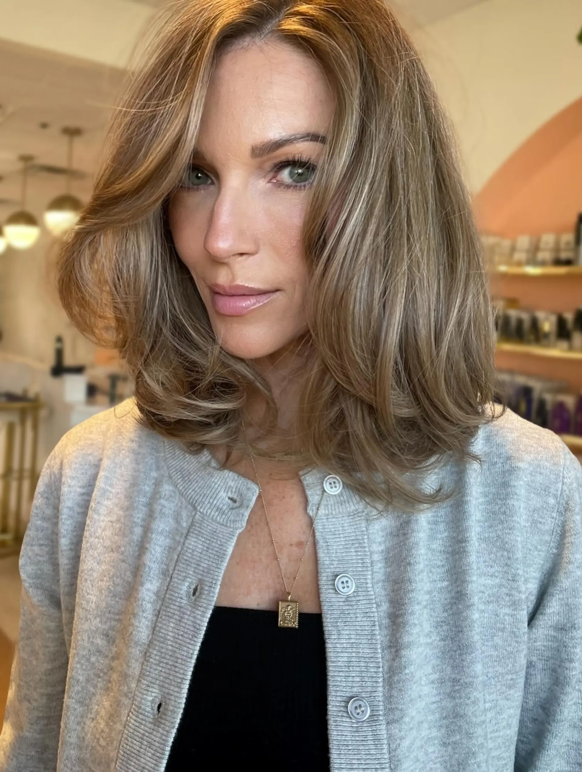 Shoulder-length haircut featuring soft, bouncy layers and face-framing volume, enhanced with cool-toned highlights for seamless grey blending. 1