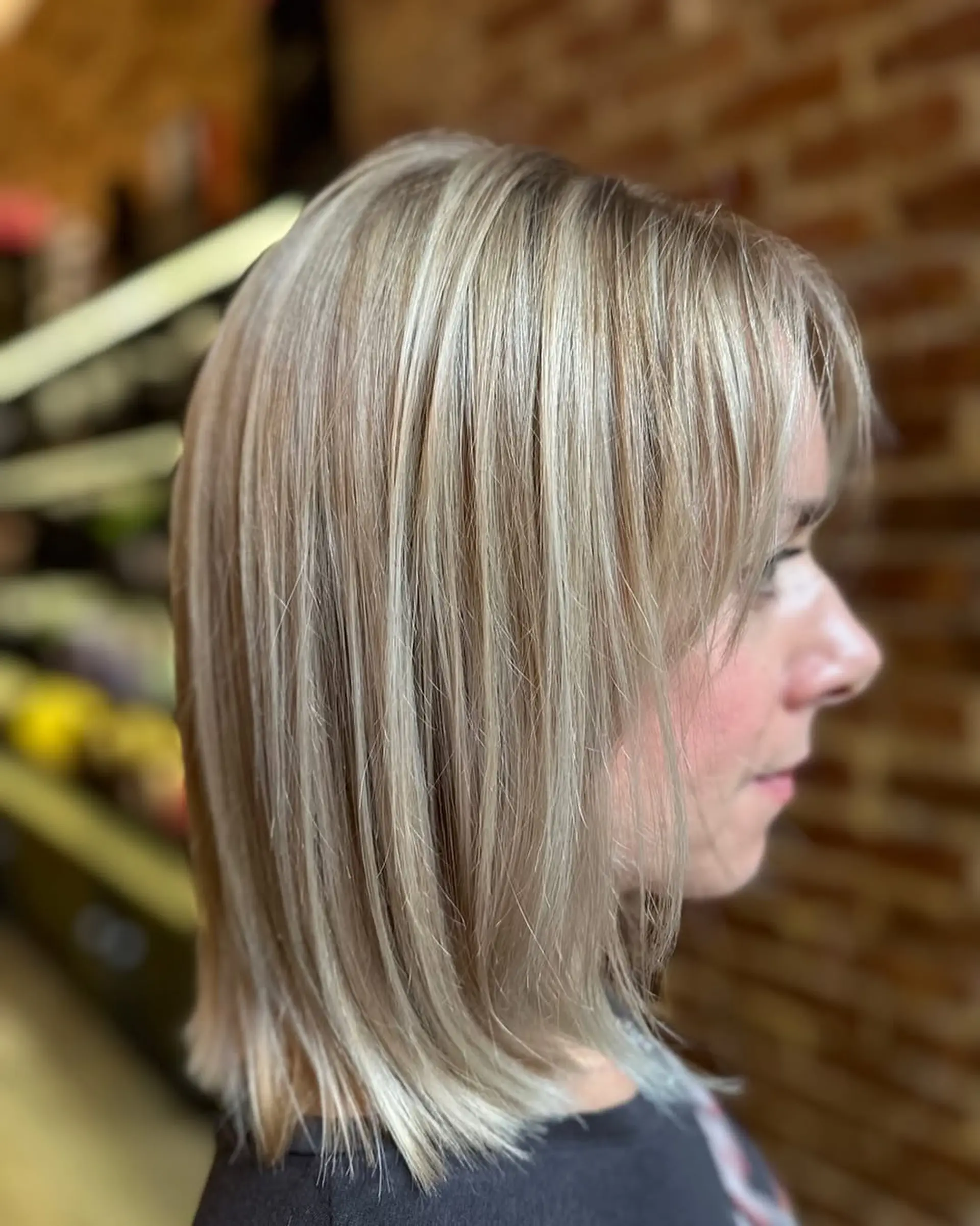 A sleek, shoulder-length cut featuring dimensional ash blonde balayage highlights. 1