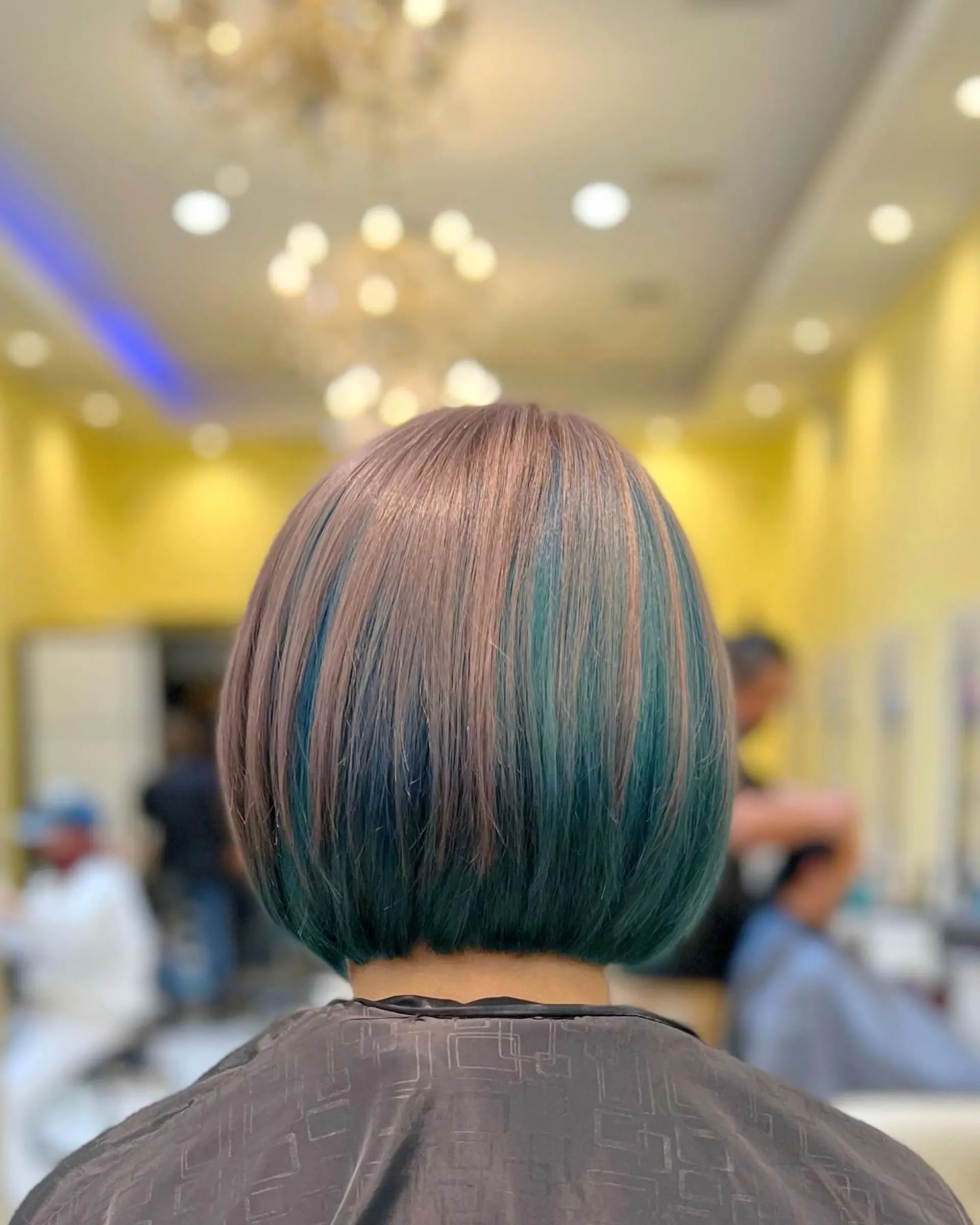 A short A-line bob with blunt ends and teal highlights. 1