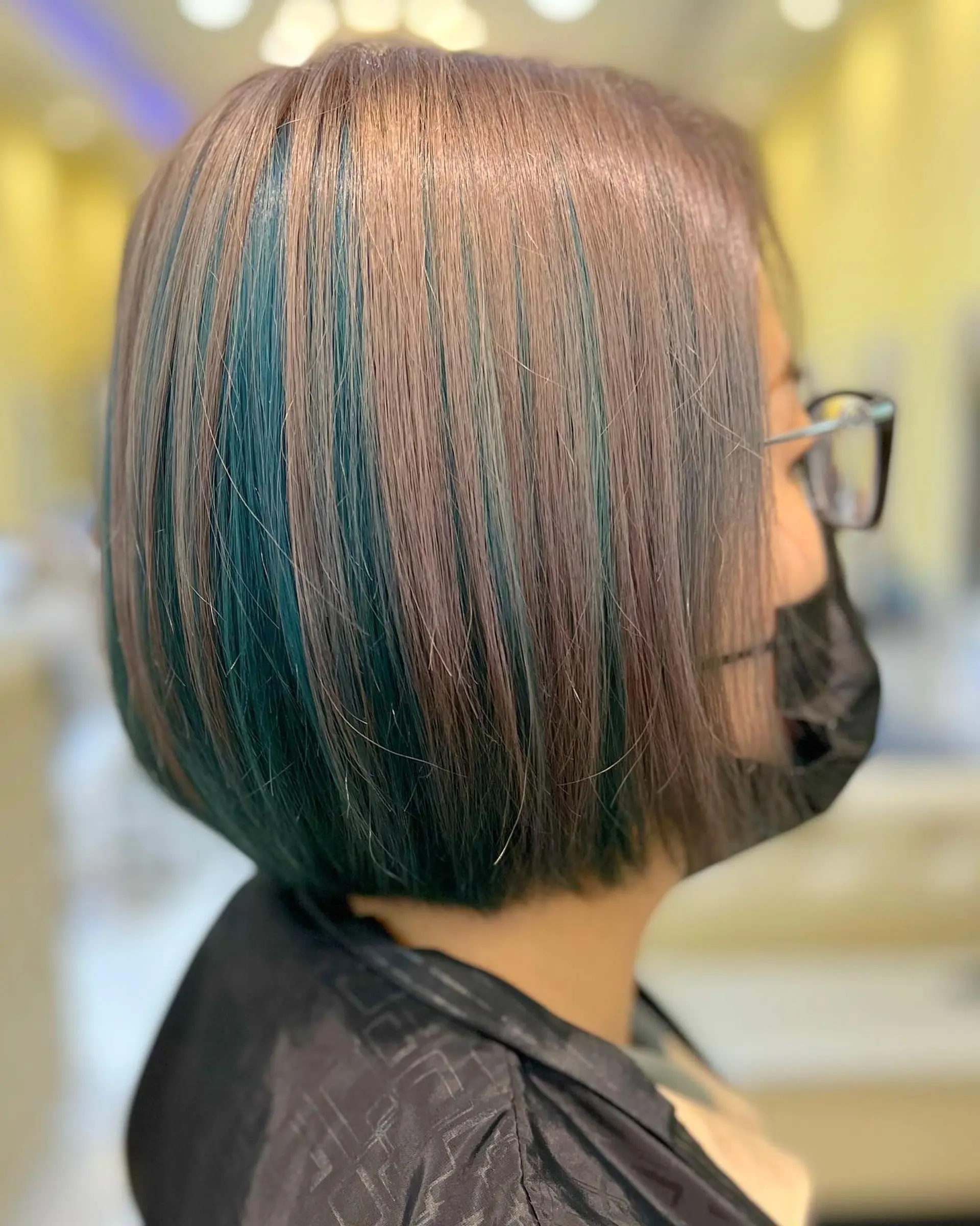 A short A-line bob with blunt ends and teal highlights. 2