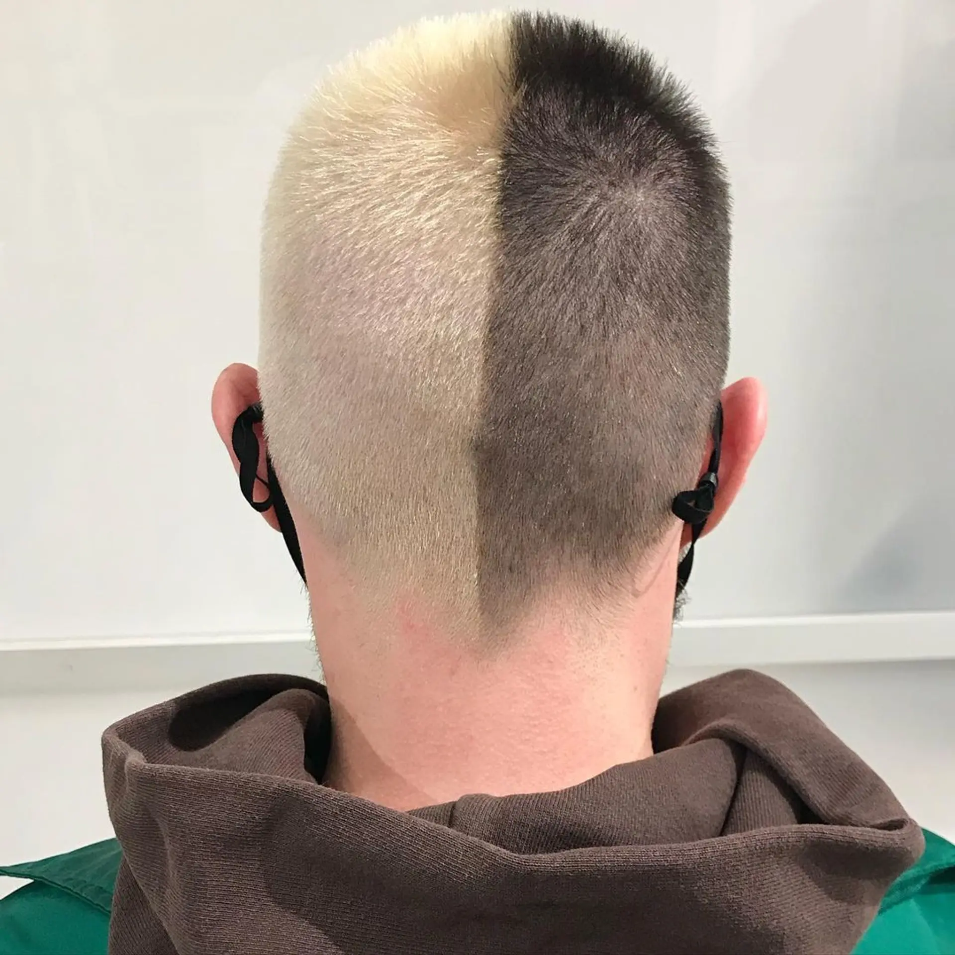 Very short buzzcut with a symmetrical split in color; one half is blonde, the other is dark brown. 1