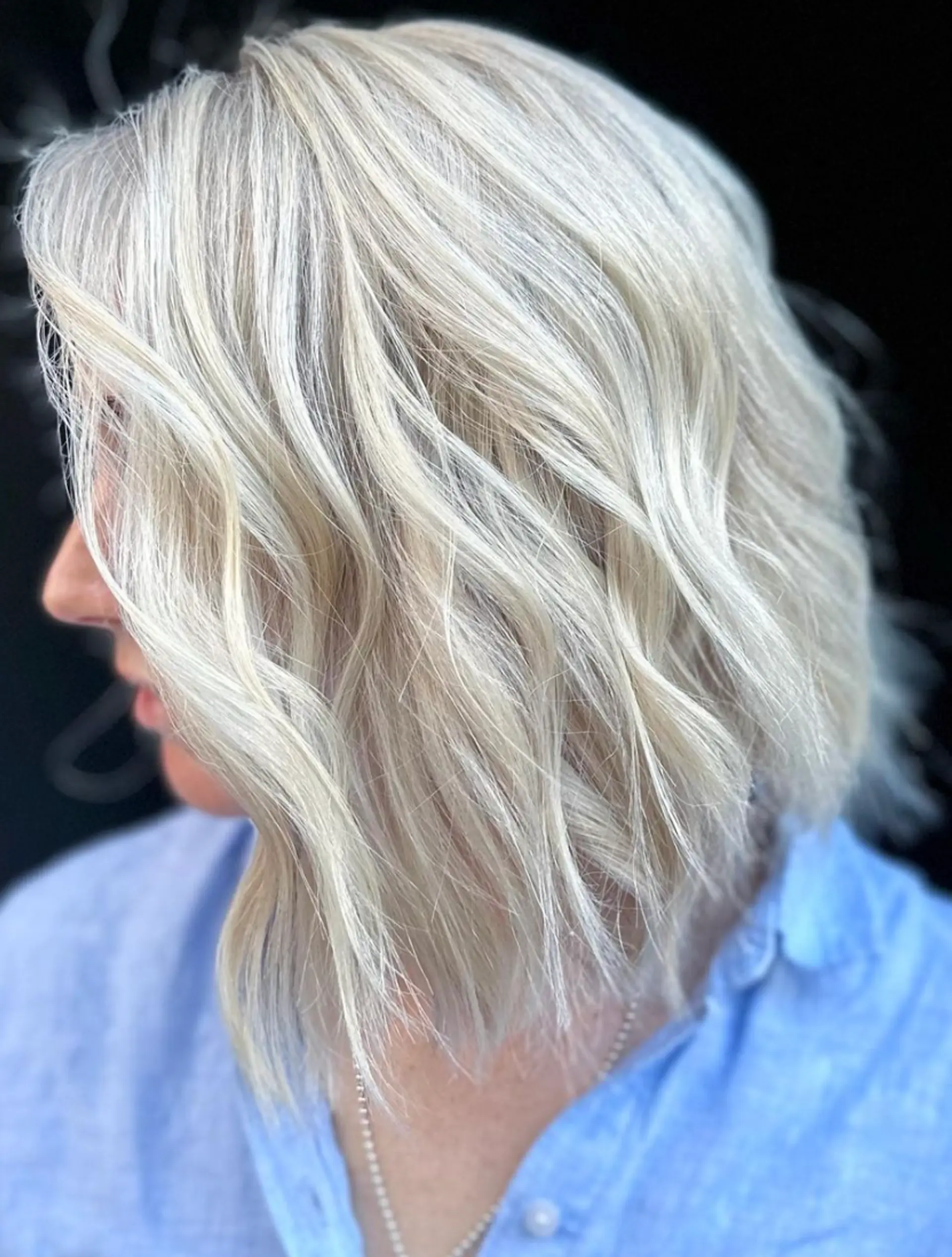 Medium-length, platinum blonde wavy hair with textured ends and a side part, featuring soft, natural waves and luminous shine.

Color by @simabeautynyc
Cut by @juliamannino_hair
 2