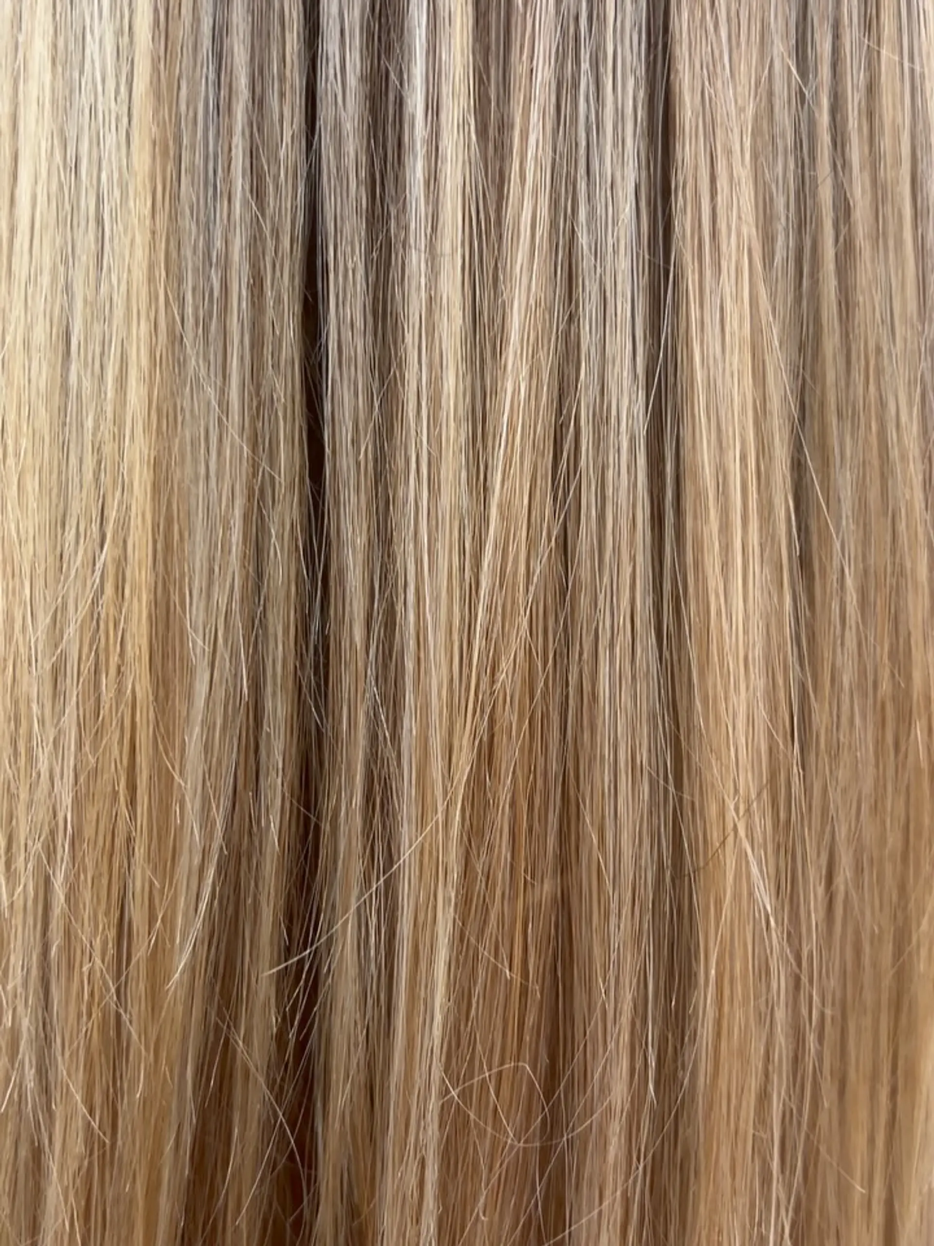 A close-up shot highlighting finely woven blonde foil highlights over a natural light brown base. 1