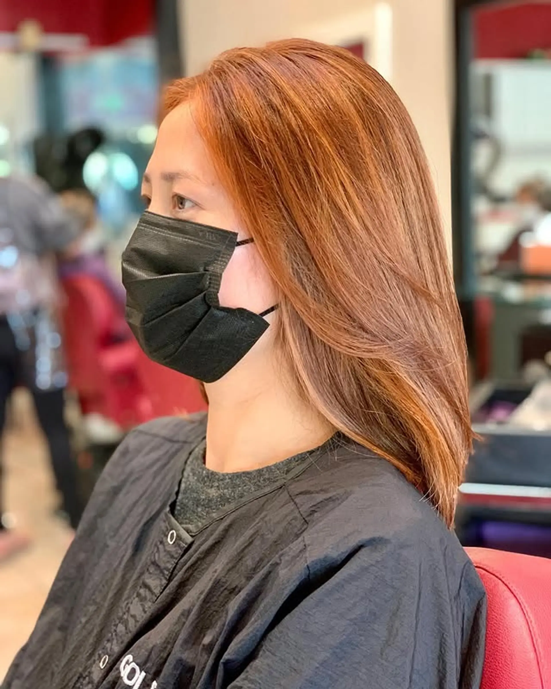 A sophisticated medium-length layered lob styled straight, showcasing a rich and warm copper auburn hue. 1