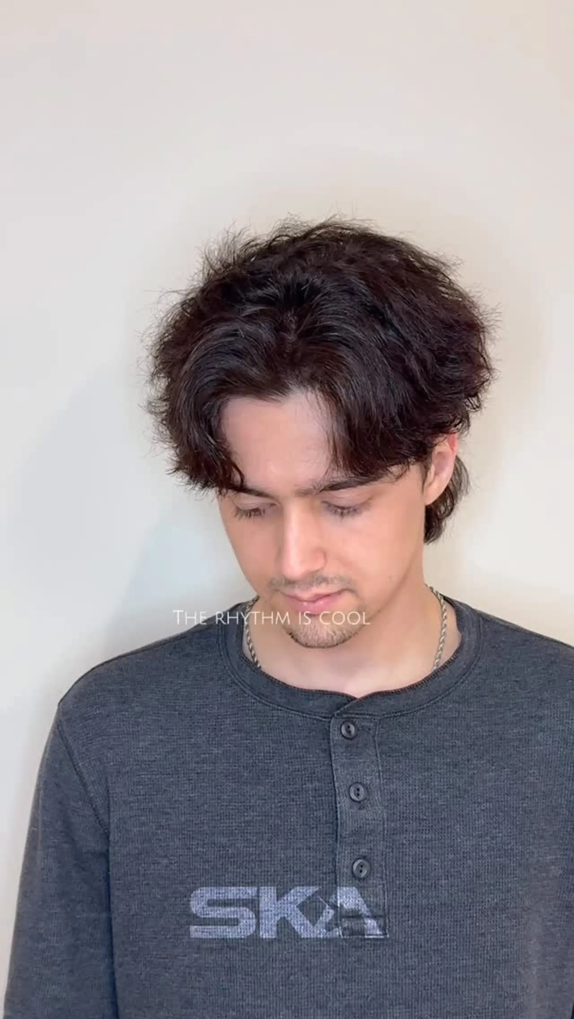 A textured short haircut with curtain bangs parted down the center, enhanced by soft wavy volume. 1