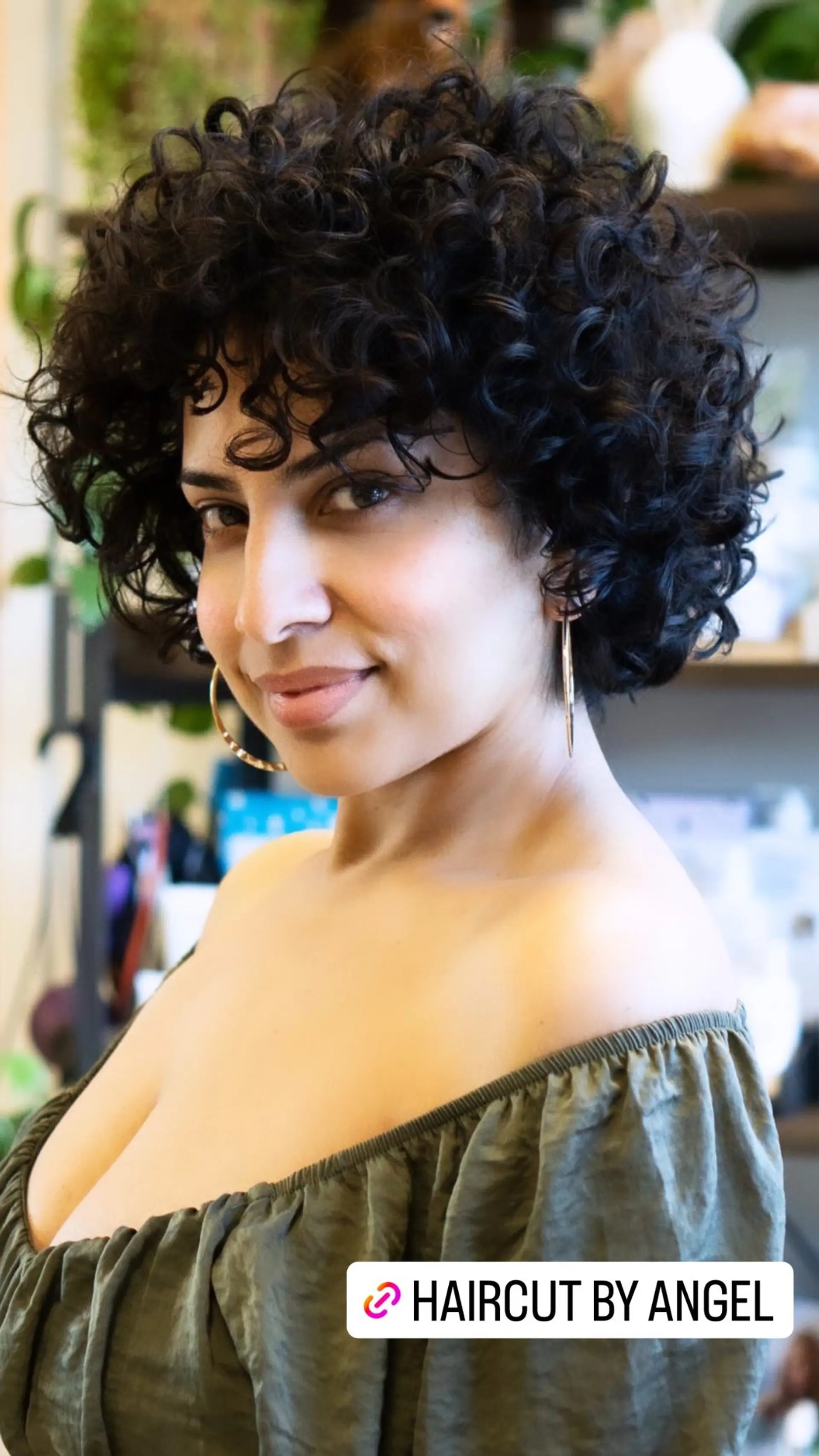 A short, curly bob with bangs that frames the face. 1