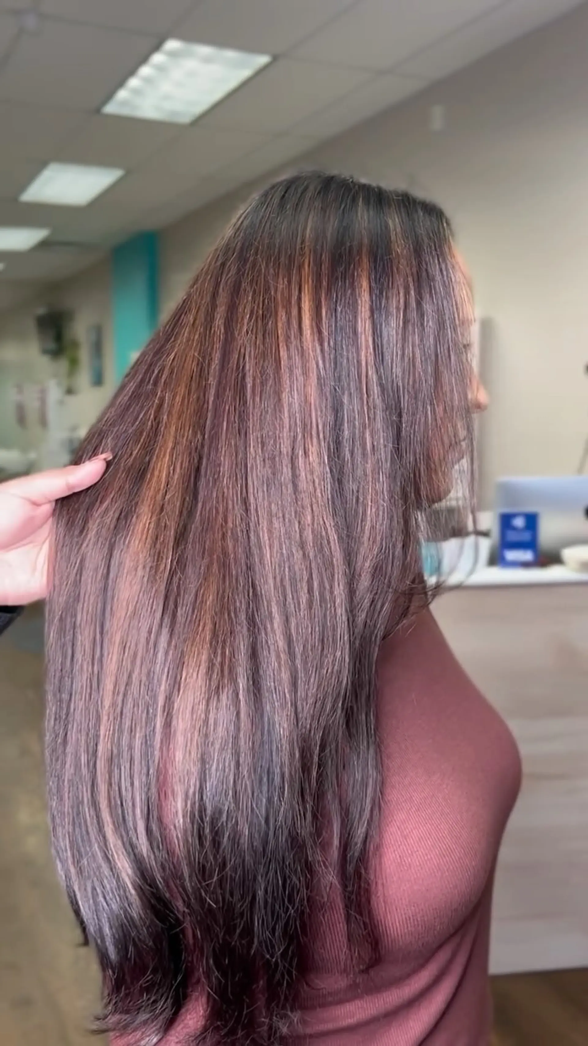 Long, smooth dark brown hair enriched with warm auburn and copper highlights styled into a sleek blowout. 1