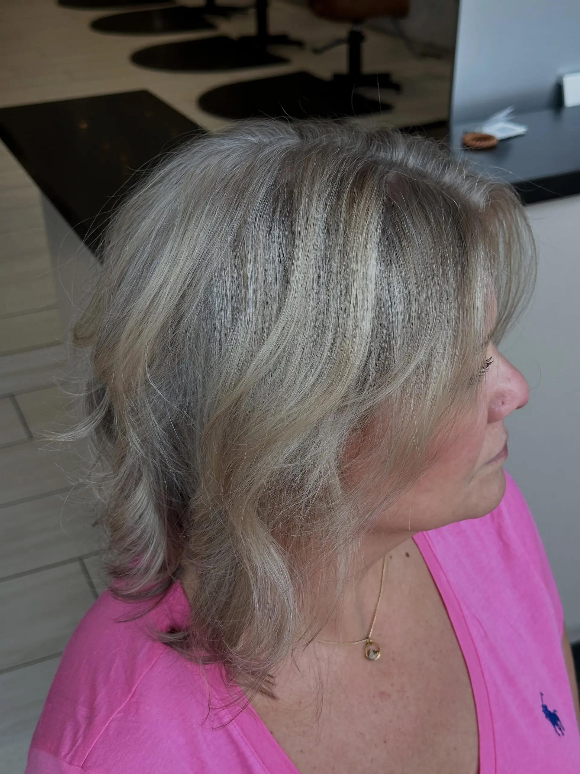 A layered, shoulder-skimming bob featuring seamless grey blending with fine cool-toned blonde highlights. 1