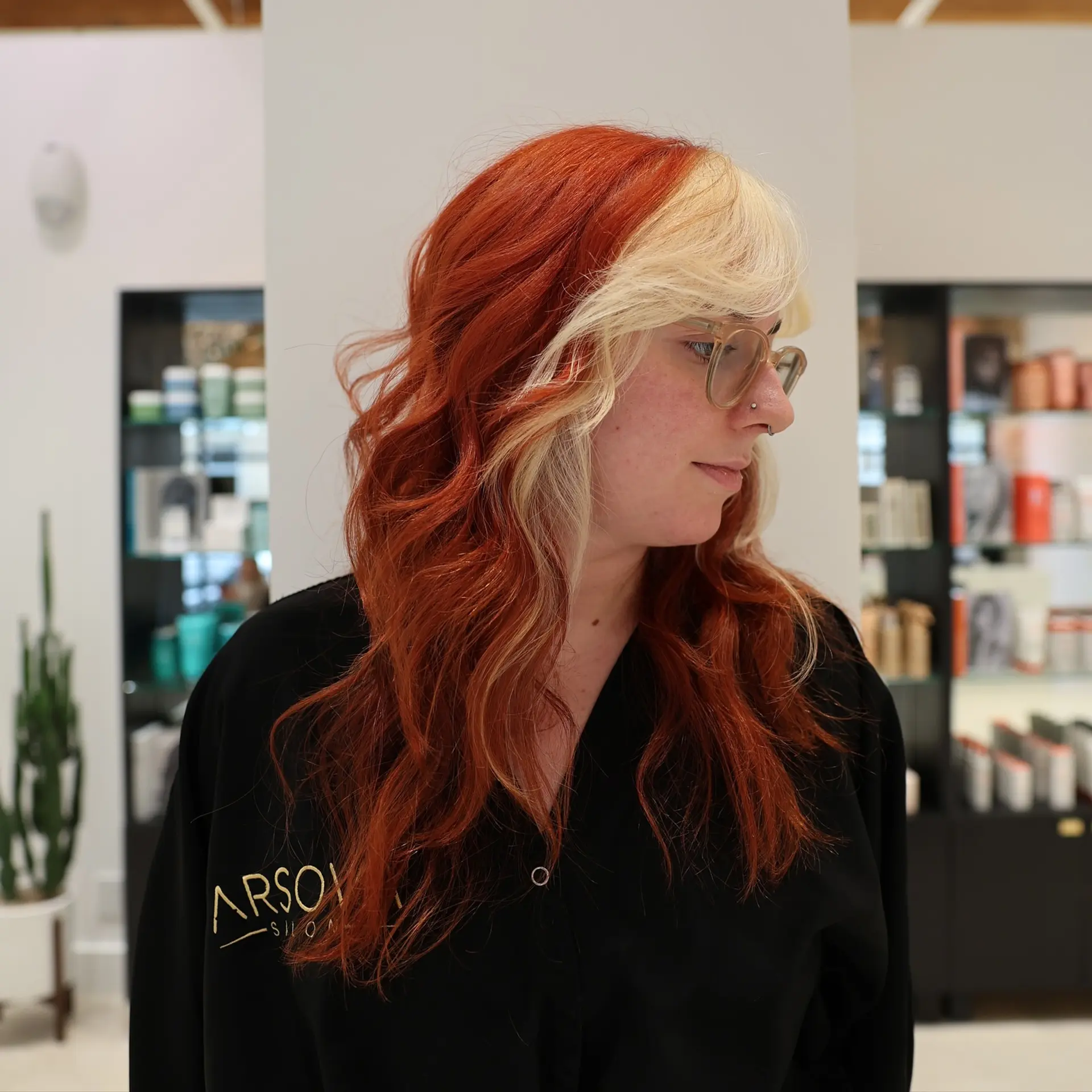 Long, wavy hair with copper red color and blonde money piece highlights. 2