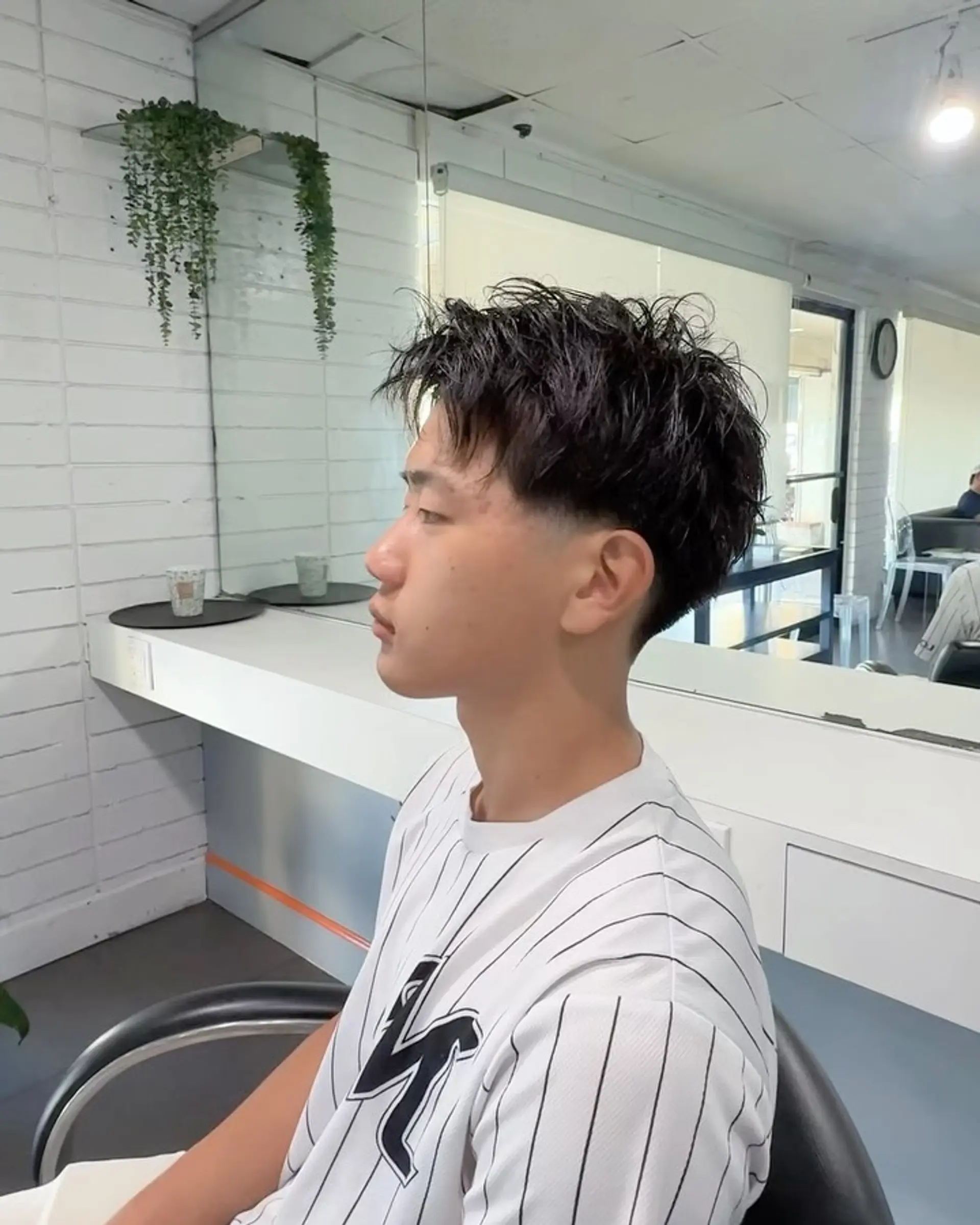 A textured short crop featuring natural piecey movement on top and a clean, low taper fade around the ear and neckline. 1