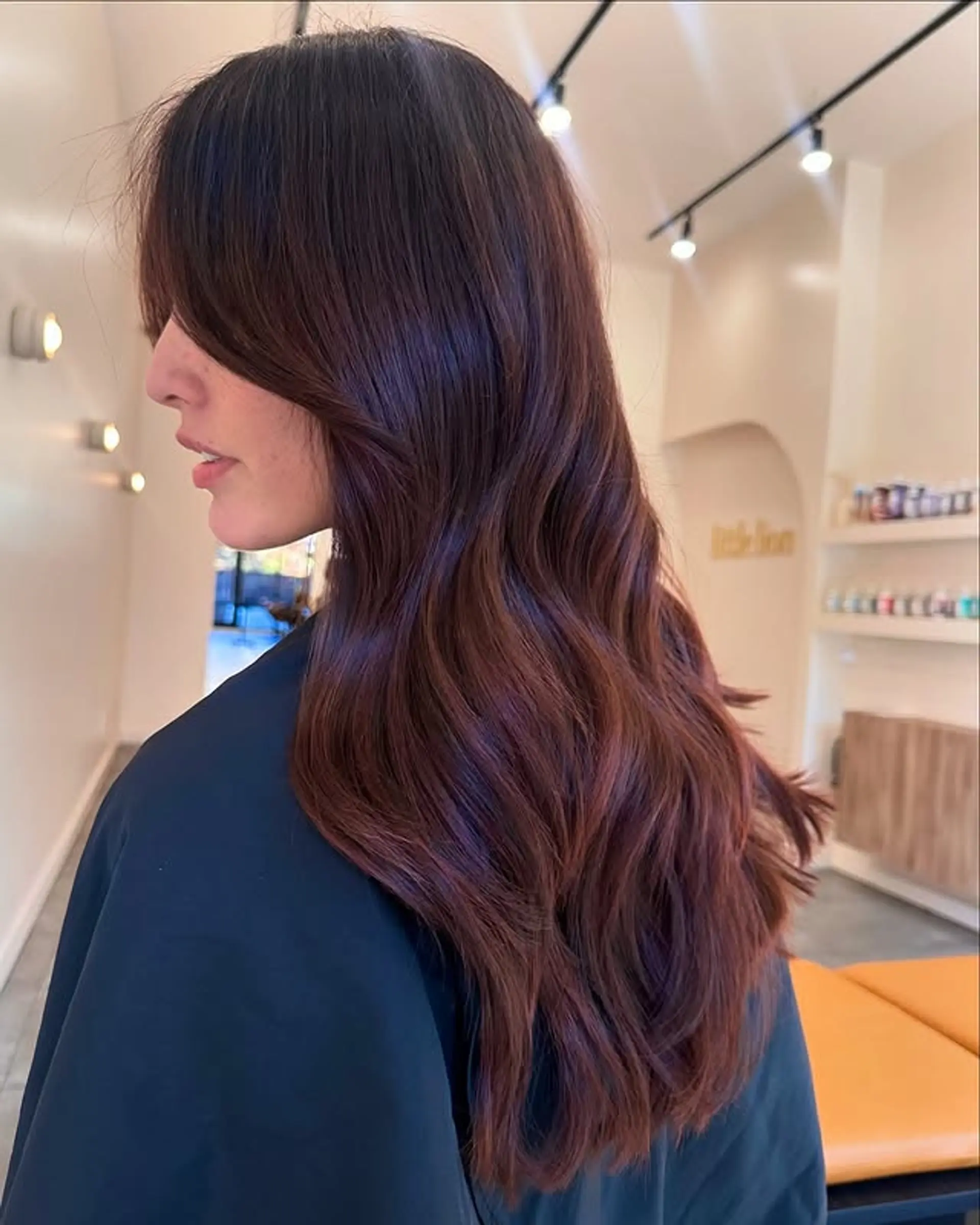 Long wavy hairstyle with layered ends and face-framing curtain bangs. 1