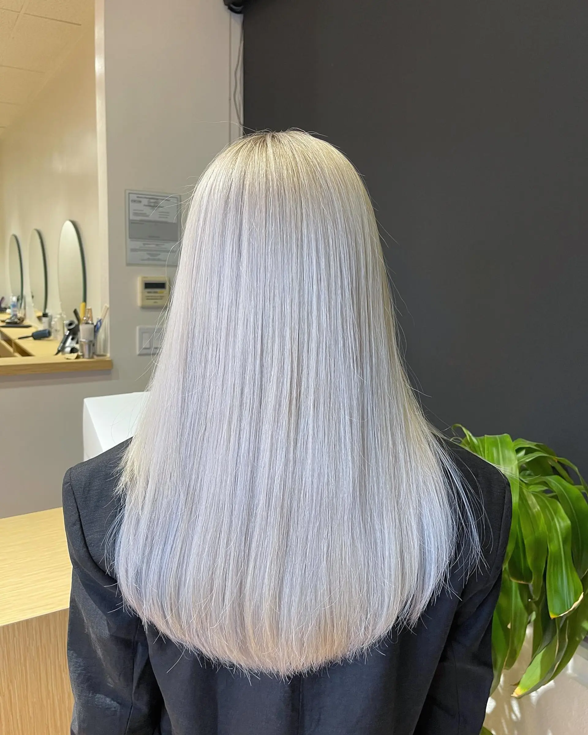 Long, sleek straight hair finished in a uniform icy silver-platinum blonde tone with soft U-shaped ends. 1