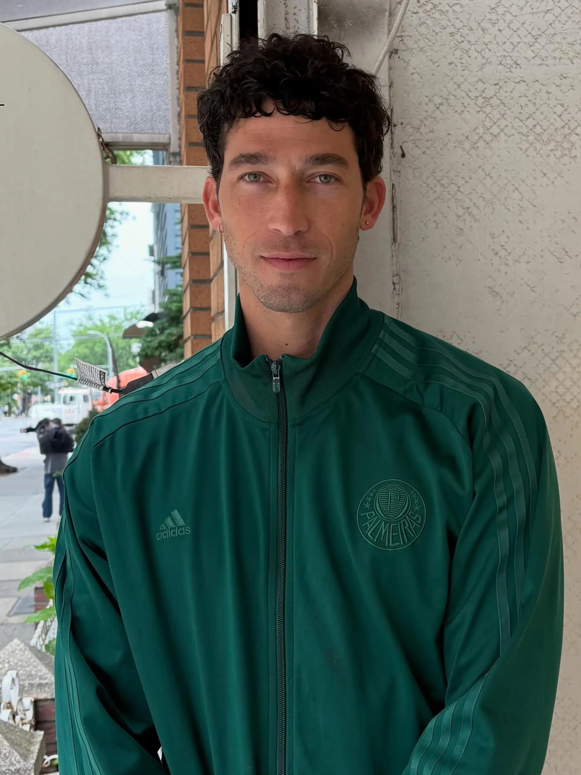 A short, natural curly haircut featuring textured layering on top and tapered sides. 1