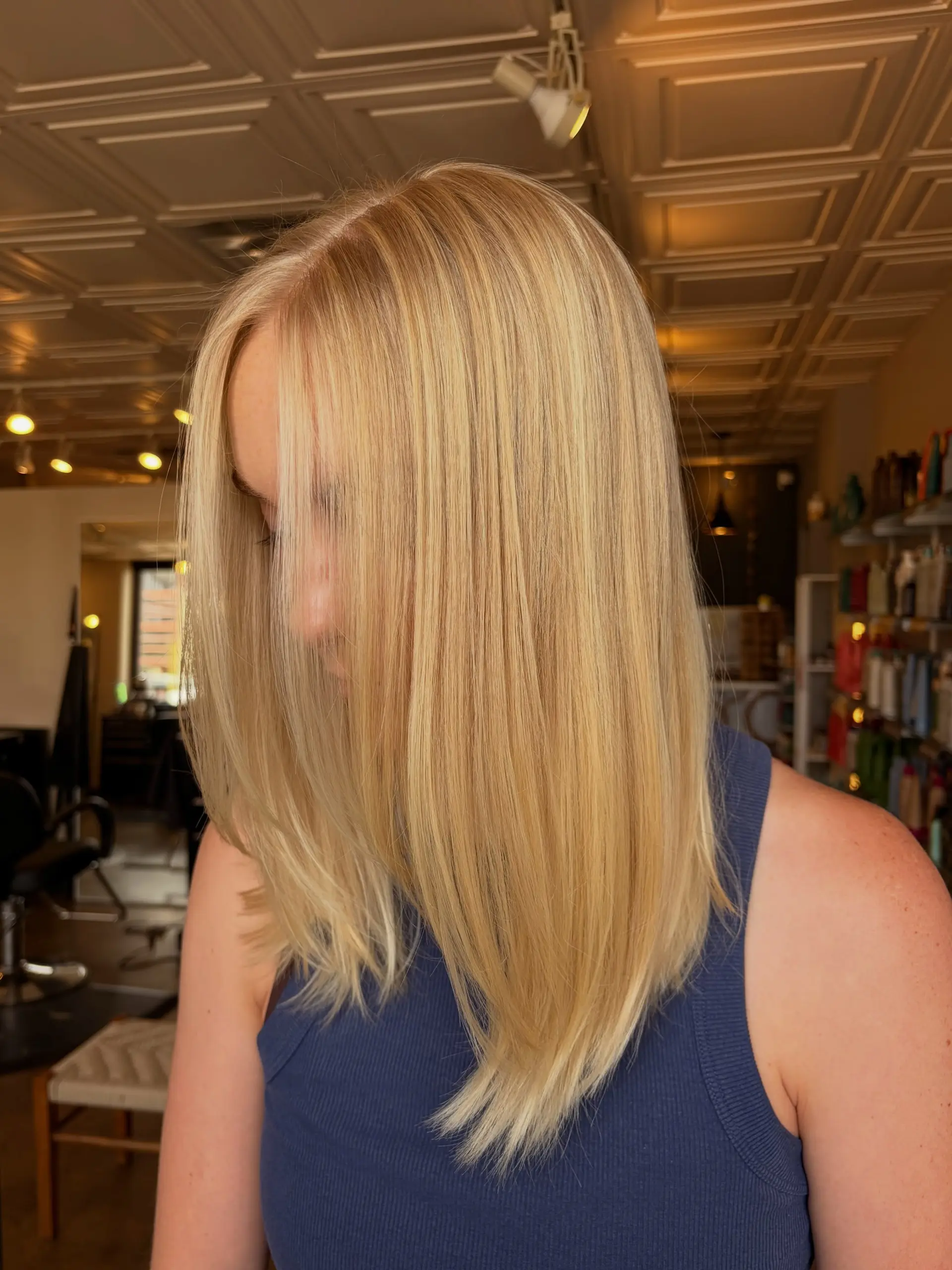 Sleek and straight medium-length hair featuring warm honey blonde tones with soft dimensional highlights. 1