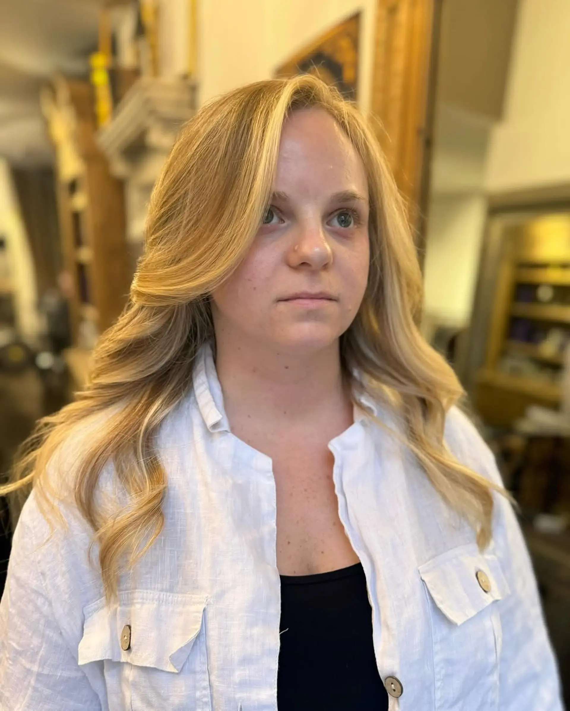 Luxurious long hair with wavy texture, featuring blonde, honey, and caramel shades in a balayage style. The natural highlights and layered ends add softness and movement. 3