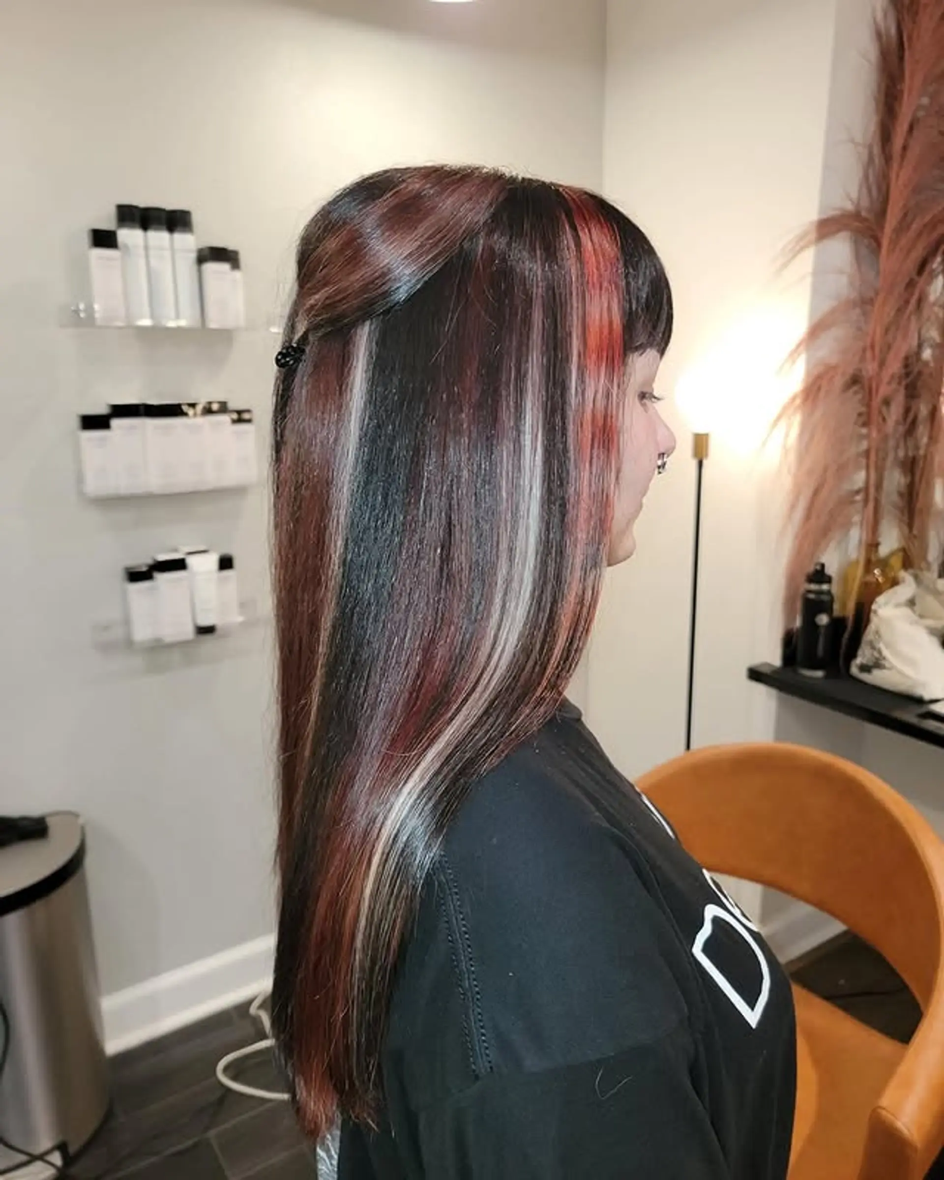 Long, straight hair with striking chunky highlights in red and platinum blonde, featuring straight bangs for a modern, edgy aesthetic. 1