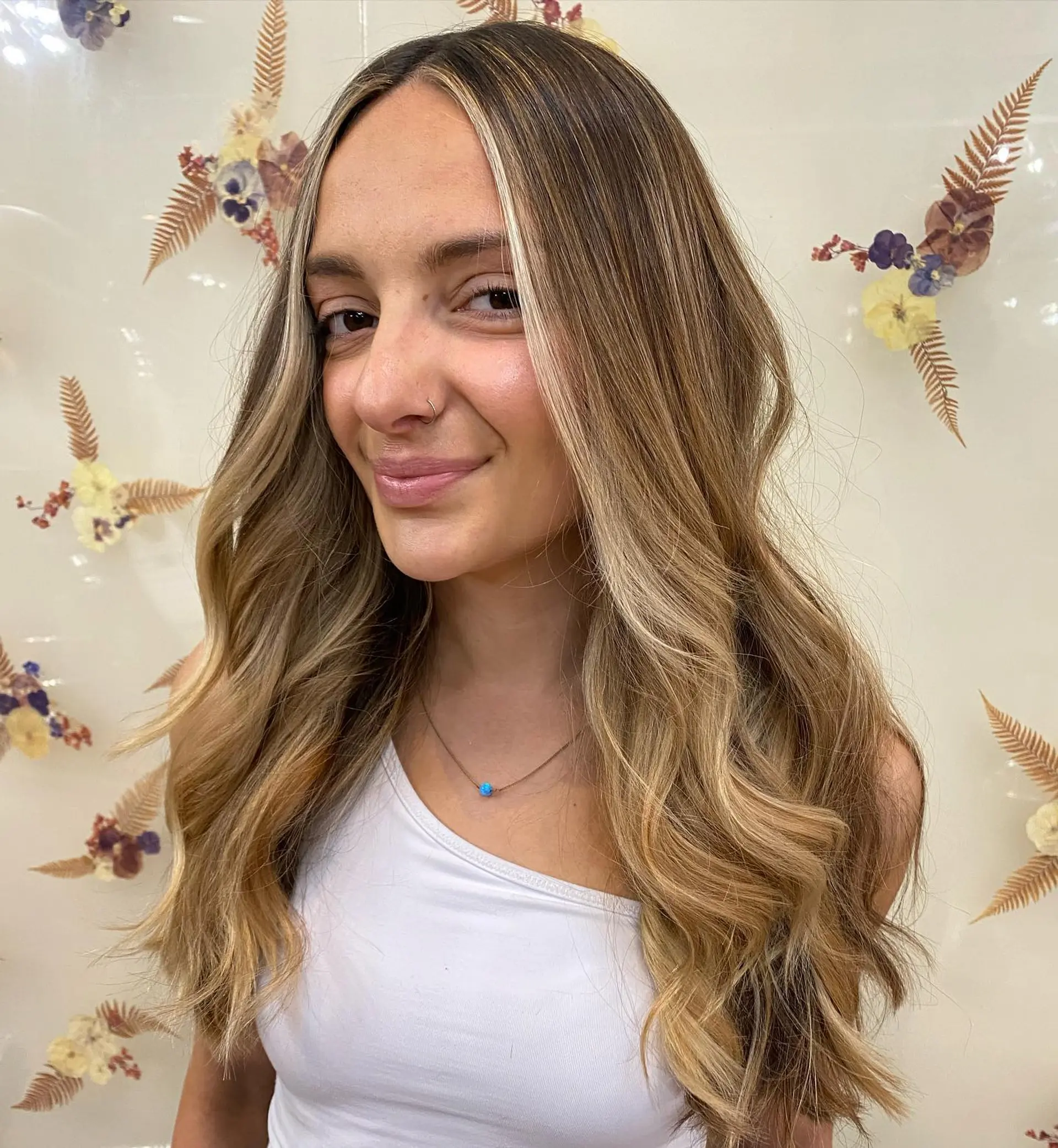 Long cascading waves featuring a bright honey-blonde balayage with delicate face-framing babylights. 1