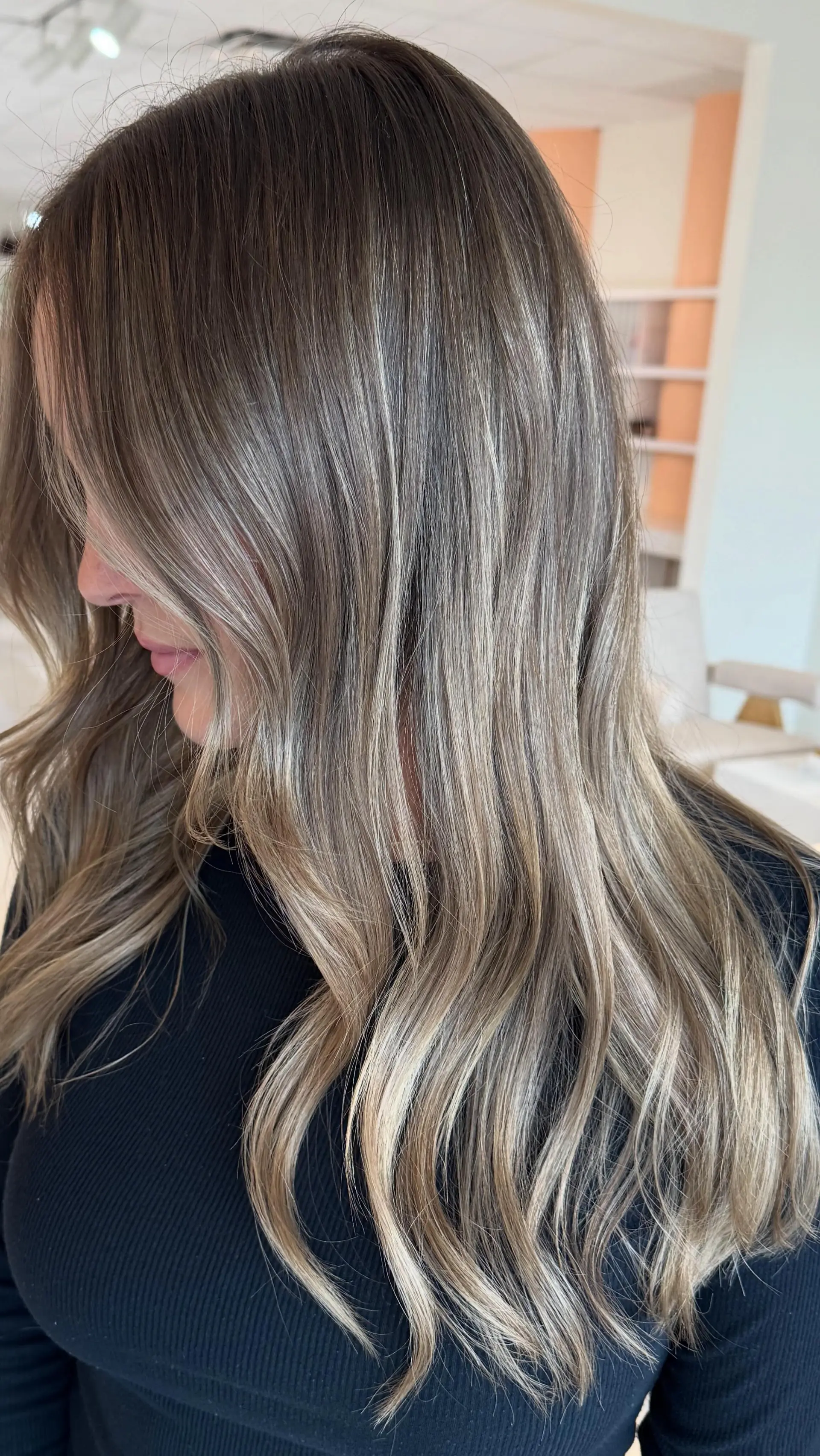 Long hair featuring seamless ash blonde balayage highlights styled in soft, loose waves. 1