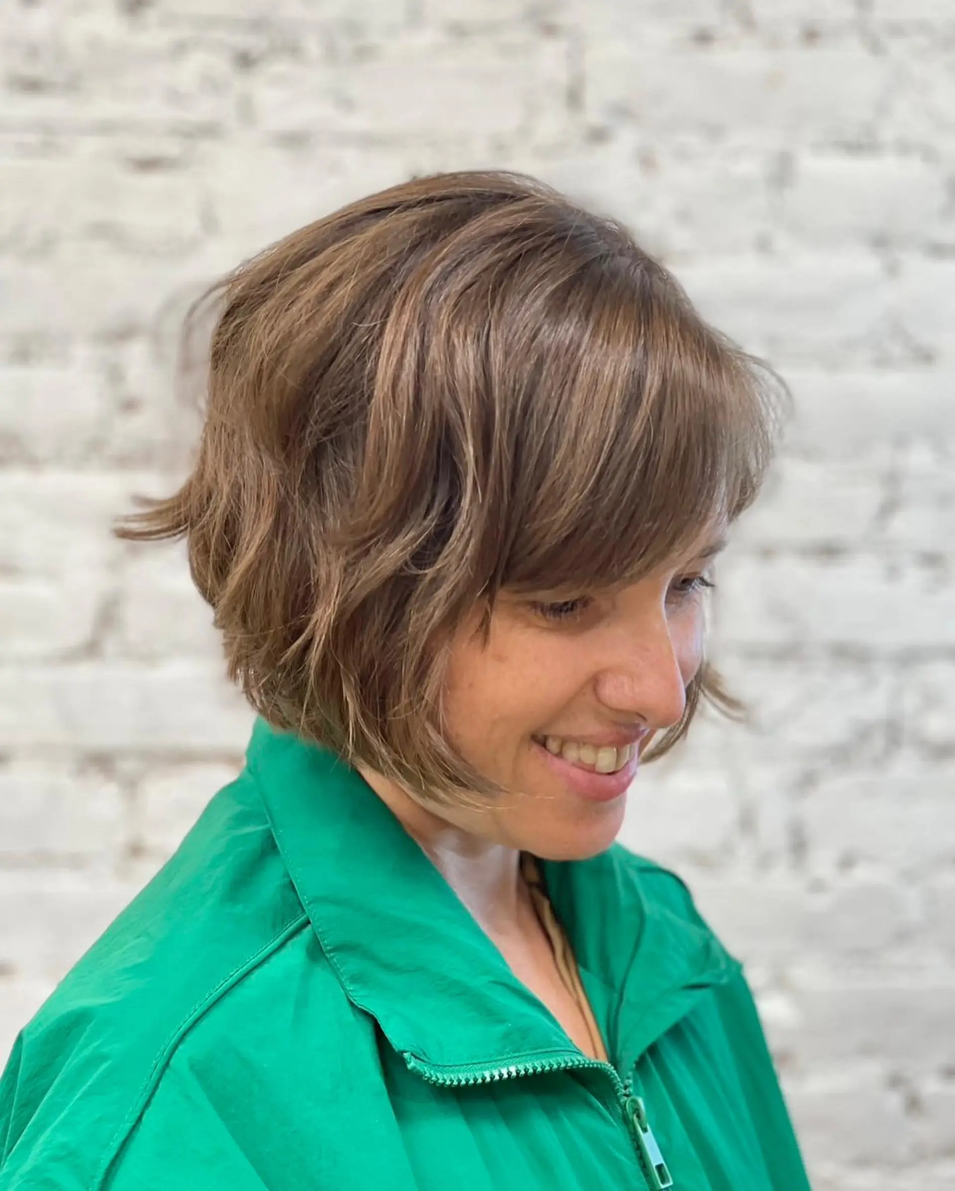 A chin-length textured short bob featuring soft waves and side-swept bangs. 1