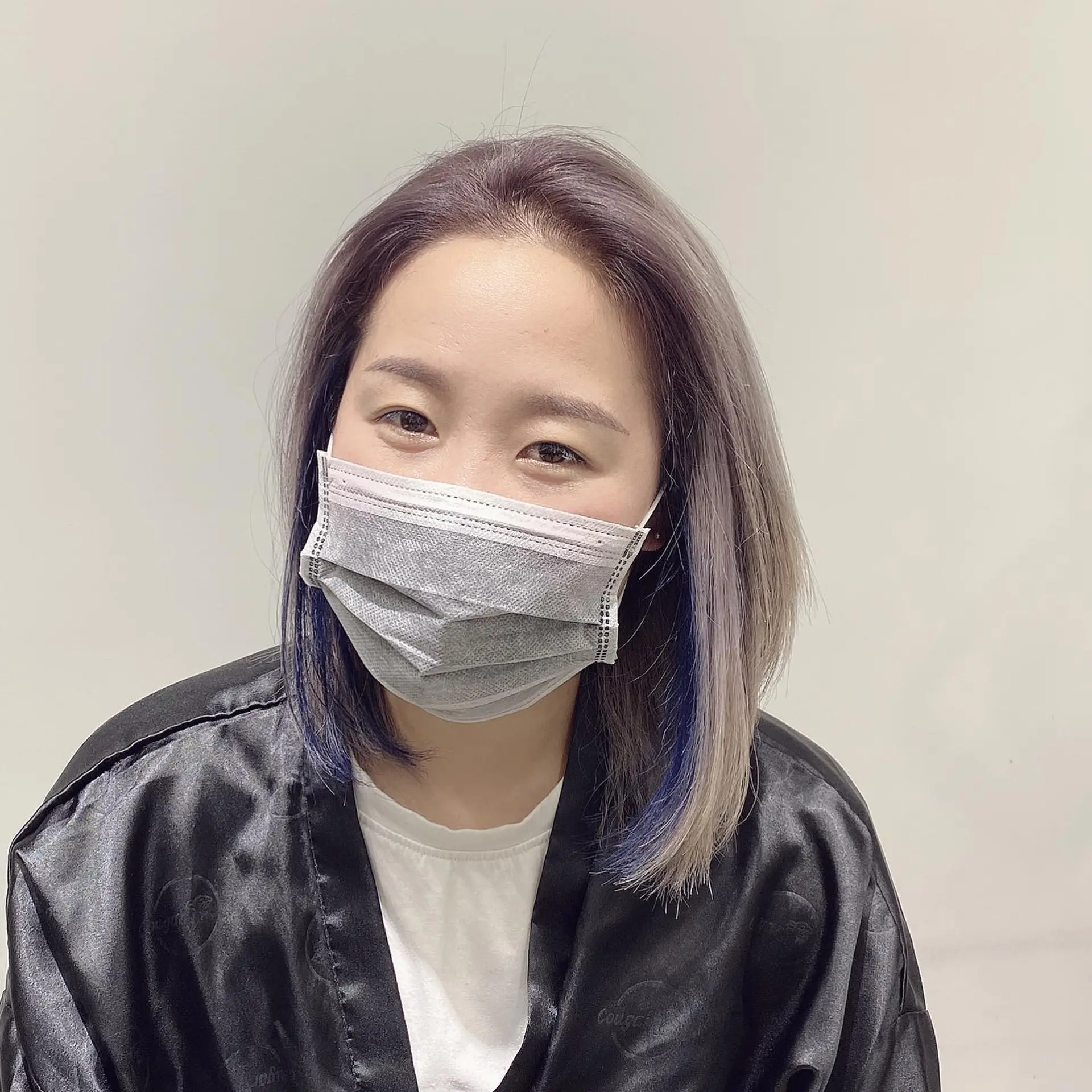 Medium-length straight hair with ash blonde and pastel purple tones, complemented by striking peekaboo blue highlights. 1