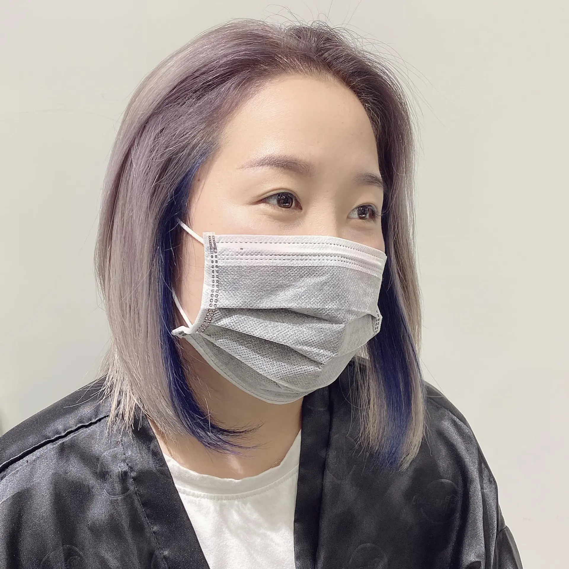 Medium-length straight hair with ash blonde and pastel purple tones, complemented by striking peekaboo blue highlights. 2