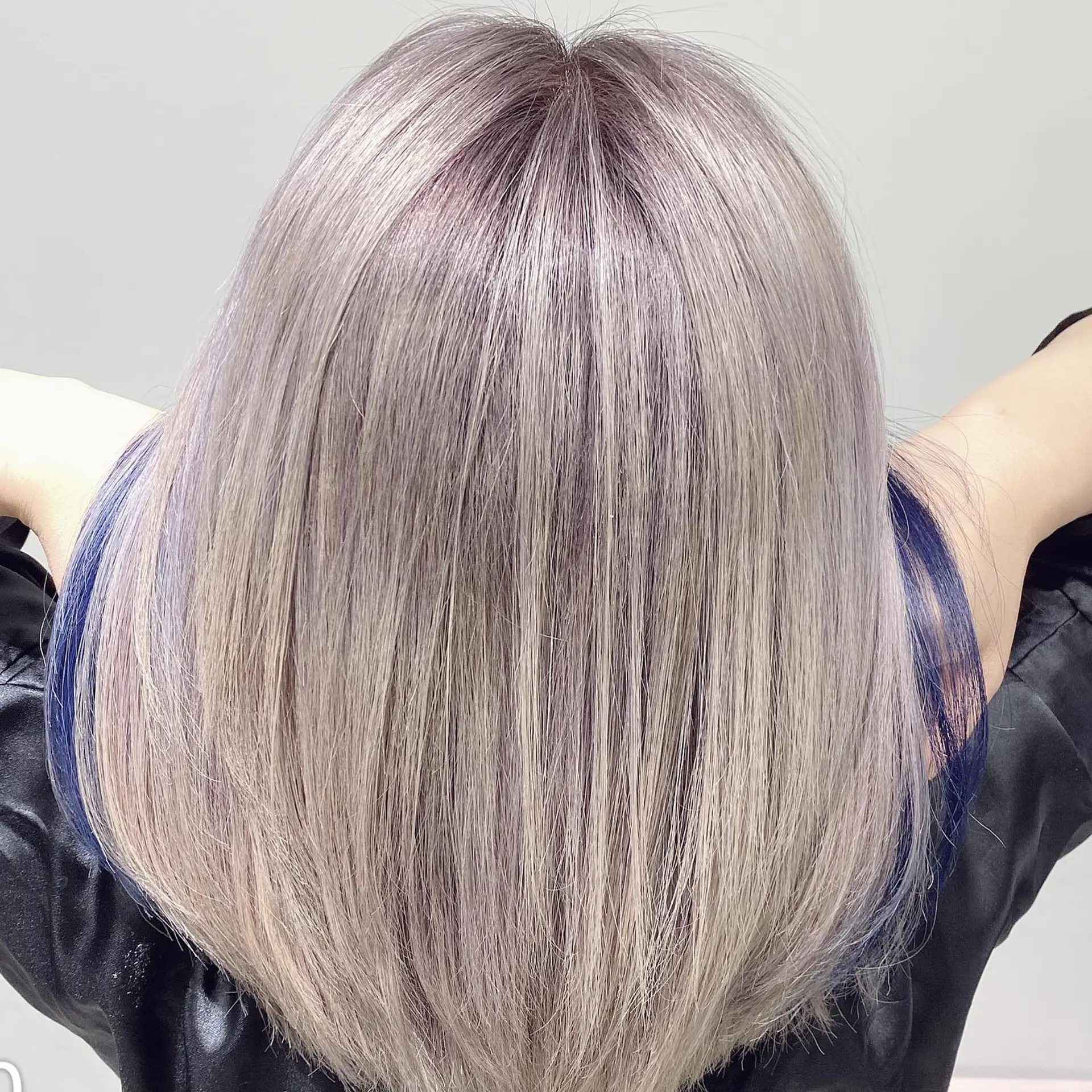 Medium-length straight hair with ash blonde and pastel purple tones, complemented by striking peekaboo blue highlights. 3
