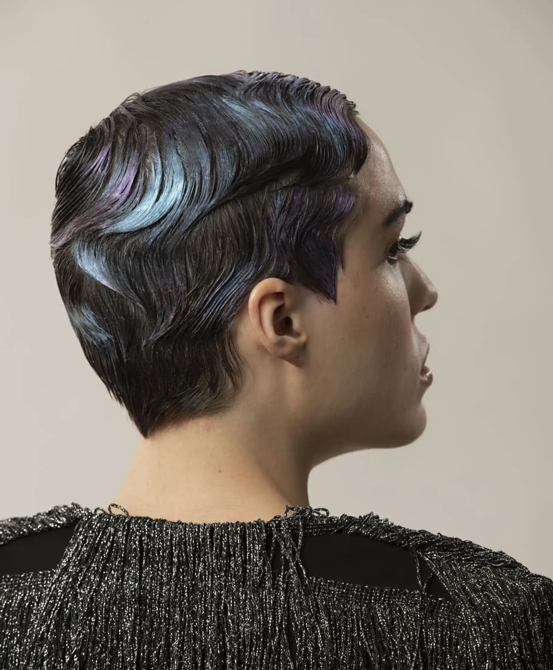 A short, wavy pixie cut styled with finger waves and a holographic color effect. 1
