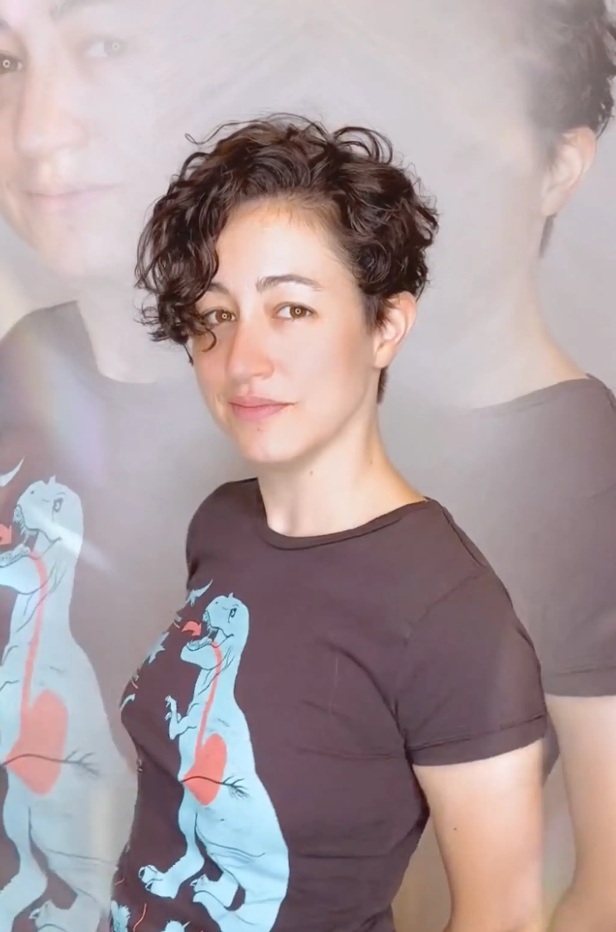 A stylish short, curly haircut with dark brown volume at the crown and tapered sides, exuding a casual chic vibe.

Cut and style by @juliamannino_hair