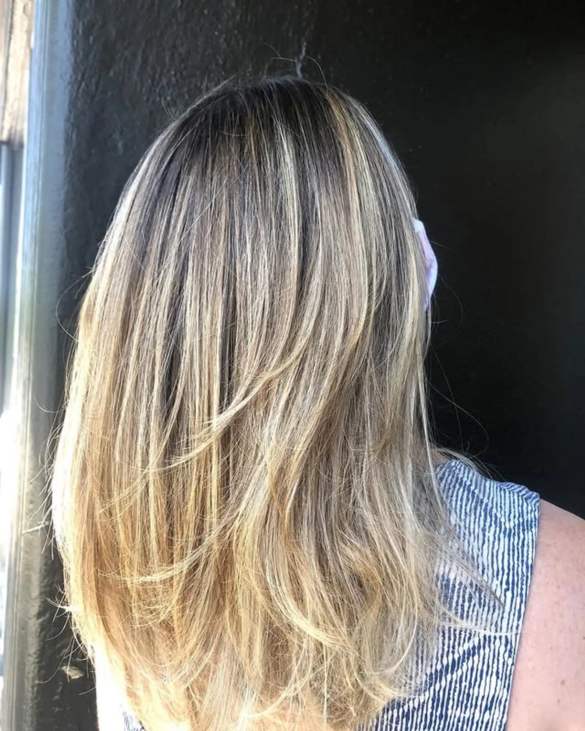 Long layered haircut with blonde balayage. 1