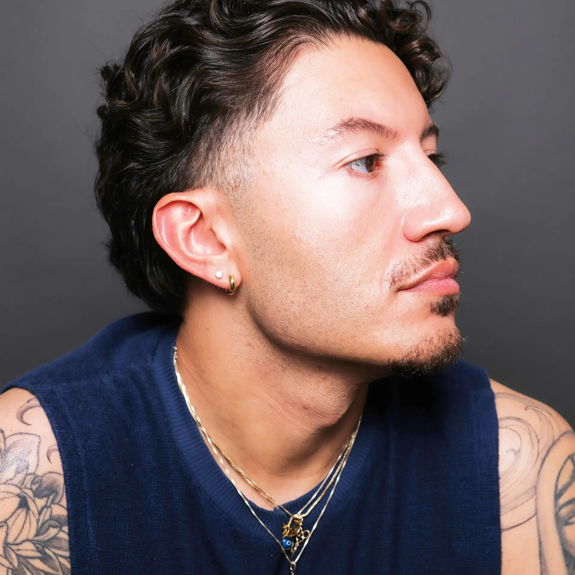 A modern men's taper cut featuring clean faded sideburns and natural wavy texture swept back. 1