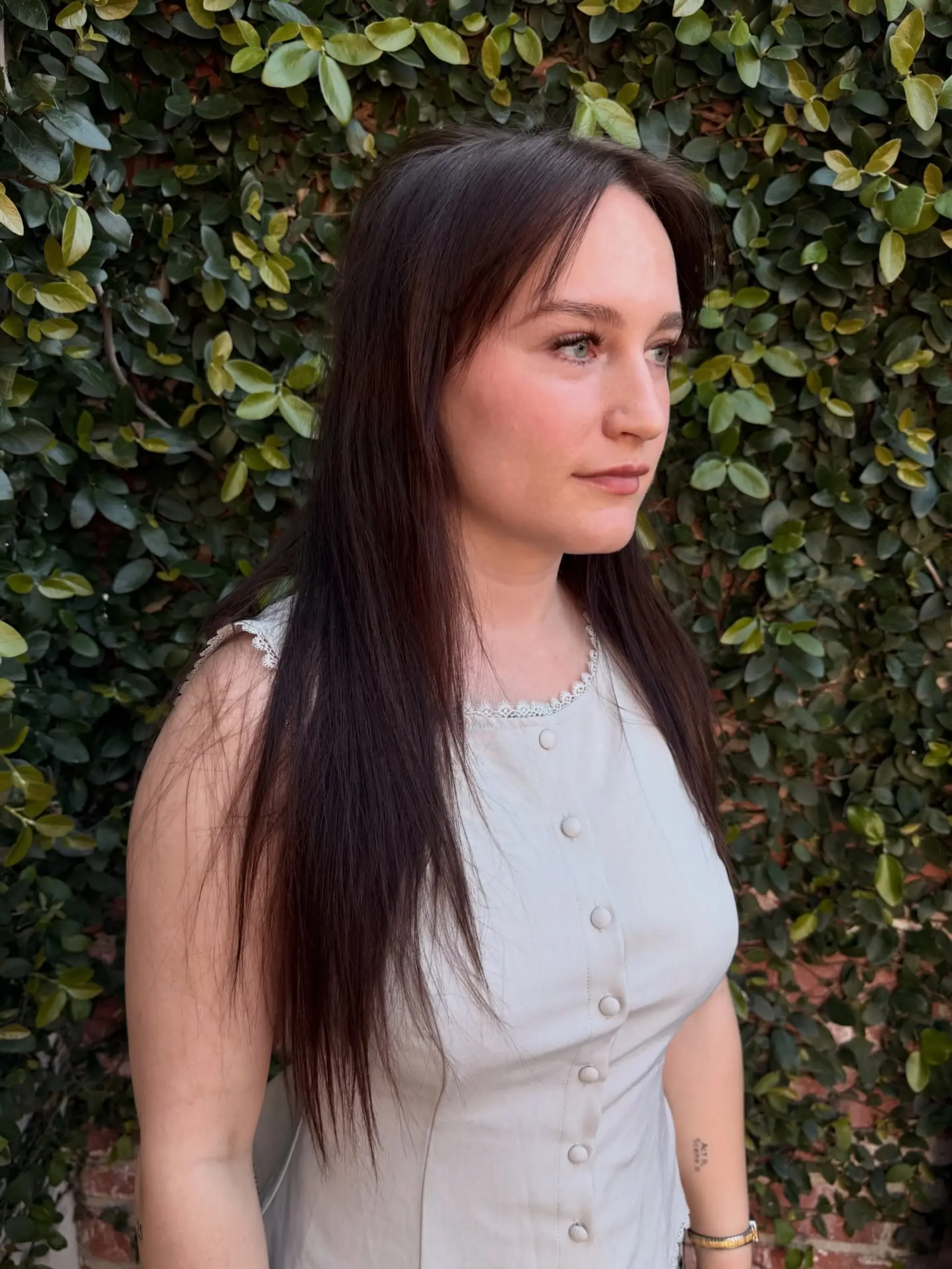 Long, straight dark brown hair with soft curtain bangs framing the face. 1