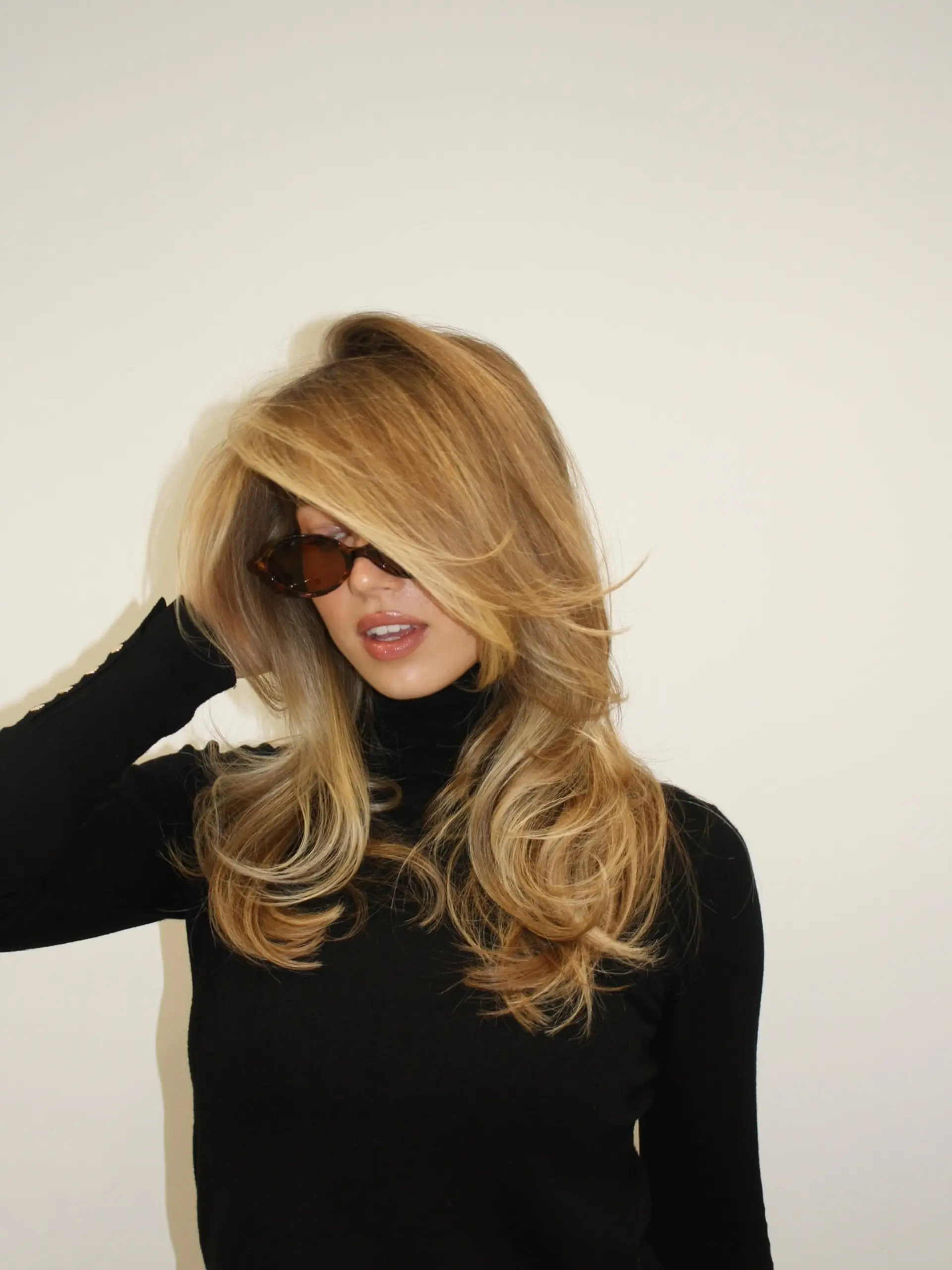 A glamorous, voluminous 90s-inspired blowout featuring long swept face-framing layers and bouncy curved ends. 1